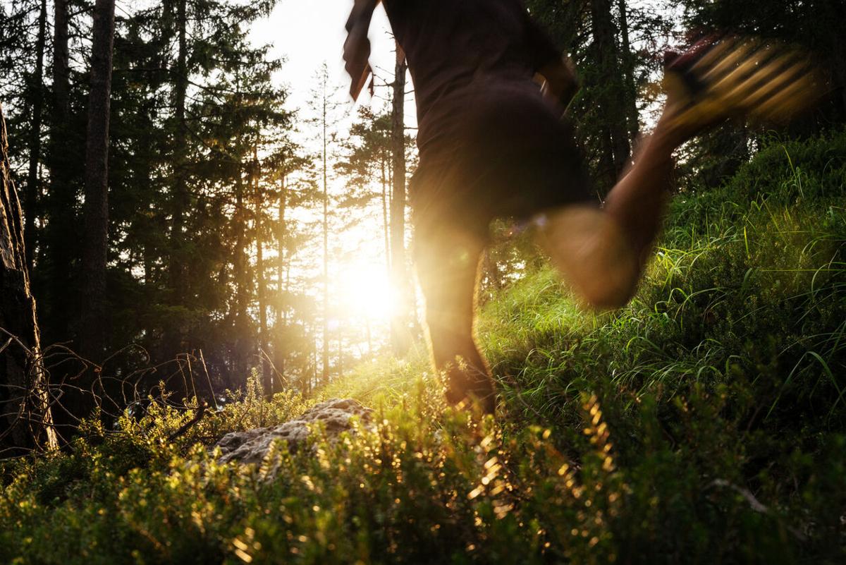 Man trail running in a mountain forest