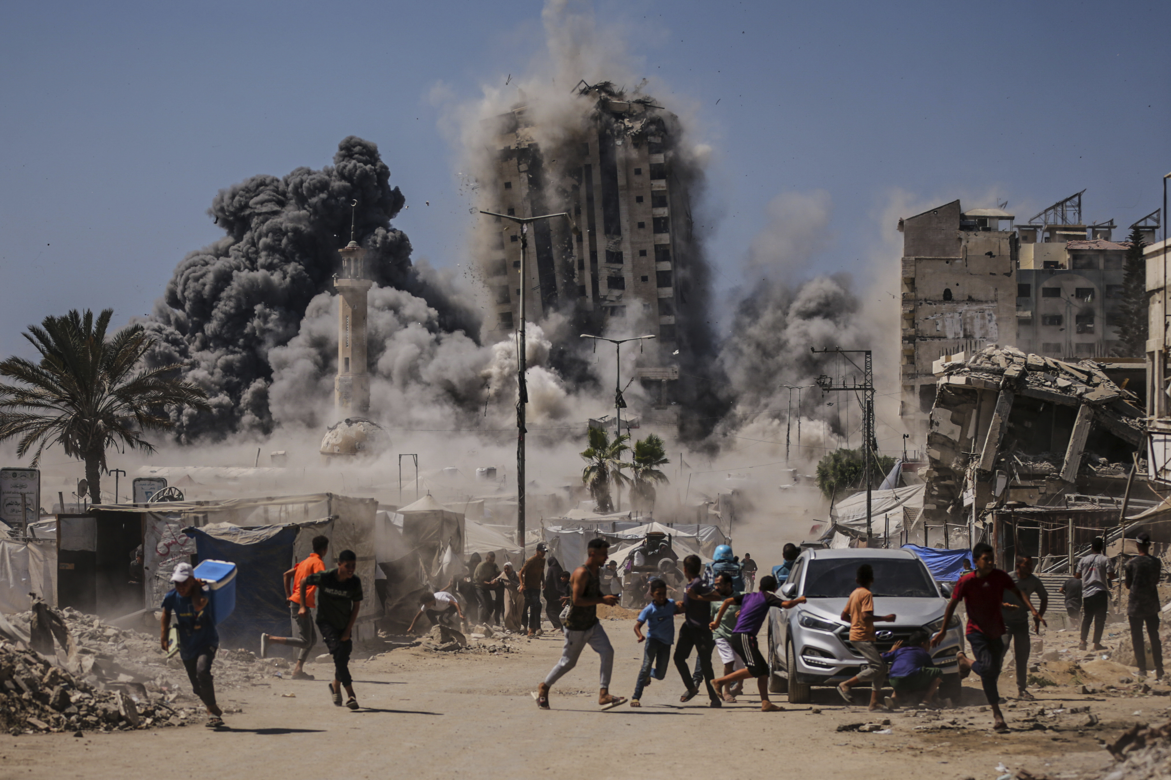 Palestinians run for cover during an Israeli airstrike on a high-rise building in Gaza City, Friday, Sept. 5, 2025, after the Israeli army issued a prior warning. (Yousef Al Zanoun - AP)