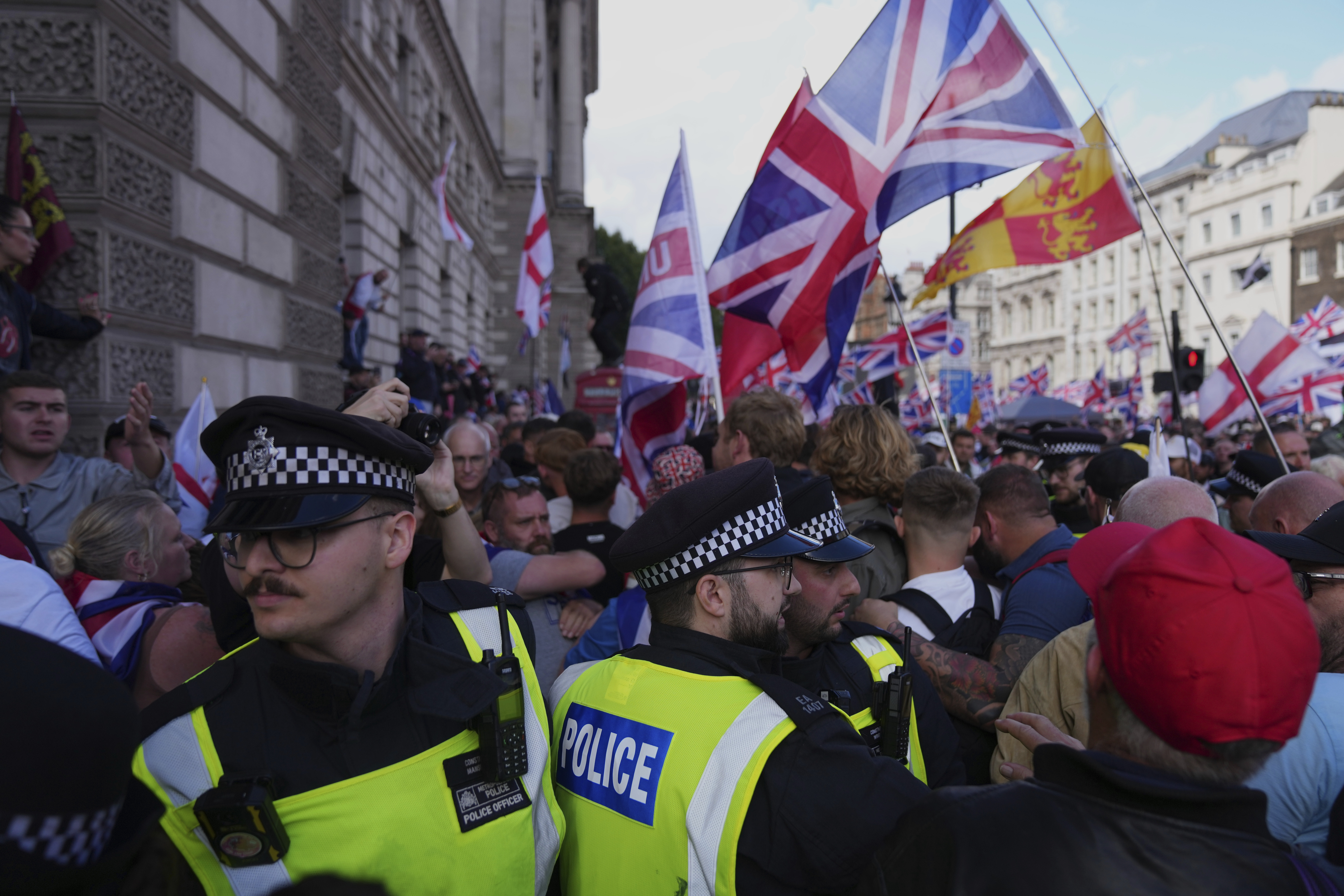 Police officers form a line in front of demonstrators from the Tommy Robinson-led Unite the Kingdom march and rally near Westminster, London, Saturday Sept. 13, 2025. (Joanna Chan - AP)