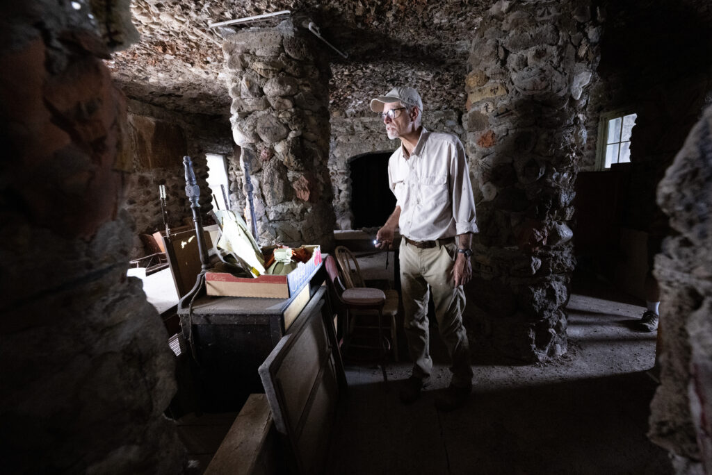 Reed Weimer shines a light on the Indian Cafe inside the World's Wonder Tower Thursday, Aug. 14, 2025, outside Genoa, Colo. The cafe fed travelers at the roadside attraction in the early days through the 1930s. (The Gazette, Christian Murdock)