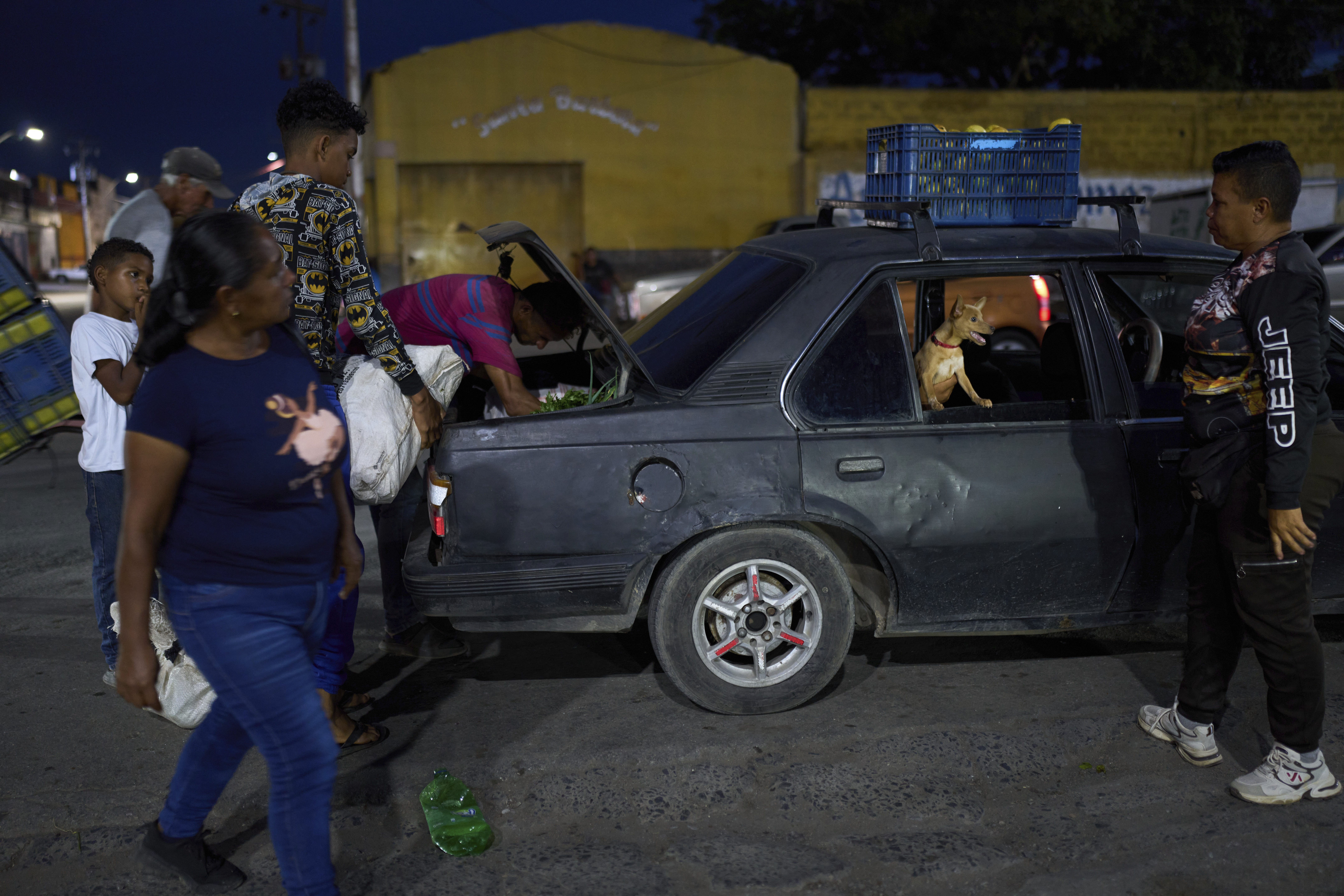 Shoppers load their goods into a car outside the municipal market in Cumana, capital of Venezuela's Sucre state, Friday, Sept. 12, 2025. (Ariana Cubillos - AP)