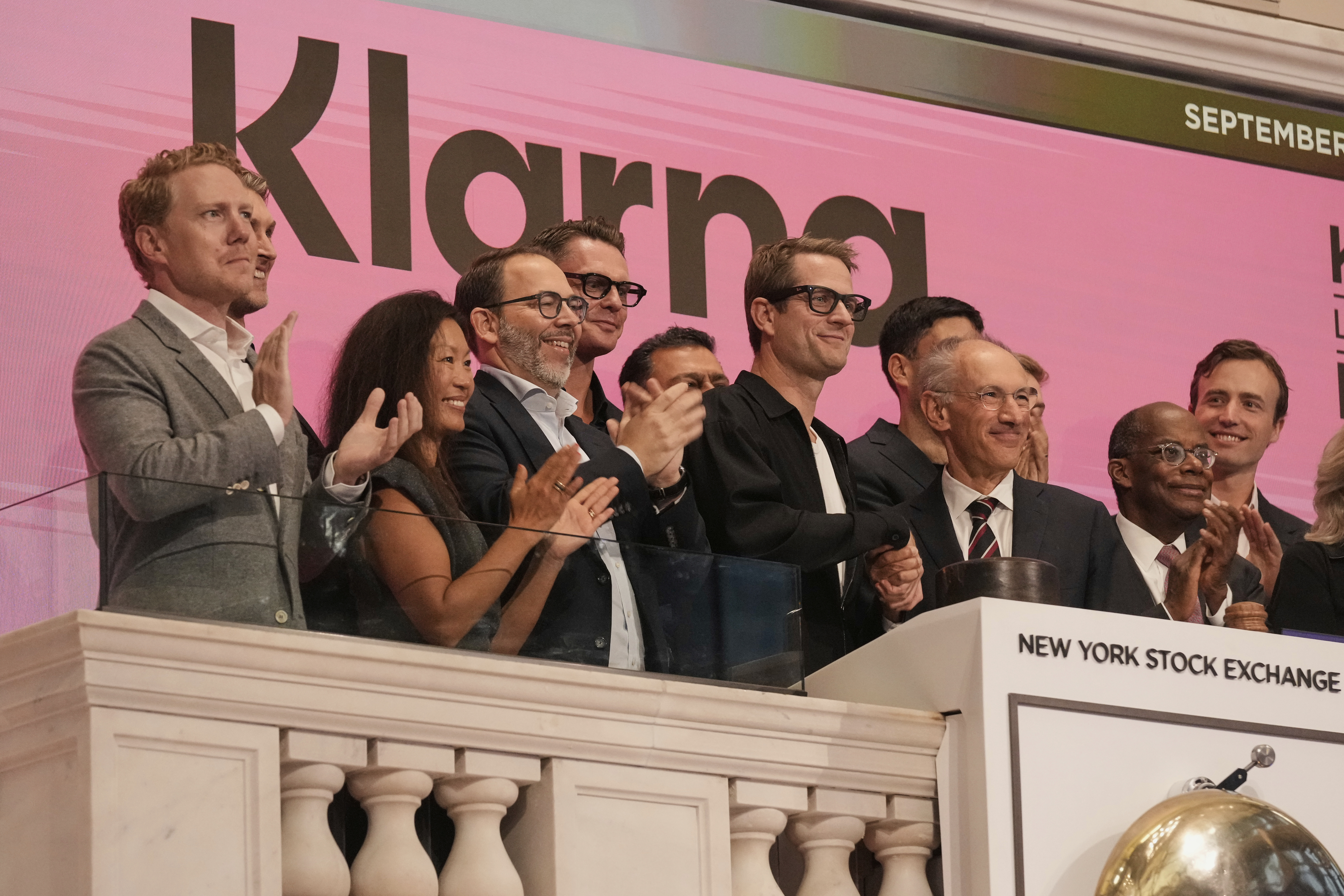 Klarna CEO Sebastian Siemiatkowski, third from right, and company Chairman Michael Moritz, second from right, shake hands as they ring the New York Stock Exchange opening bell, Wednesday, Sept. 10, 2025. (Richard Drew - AP)