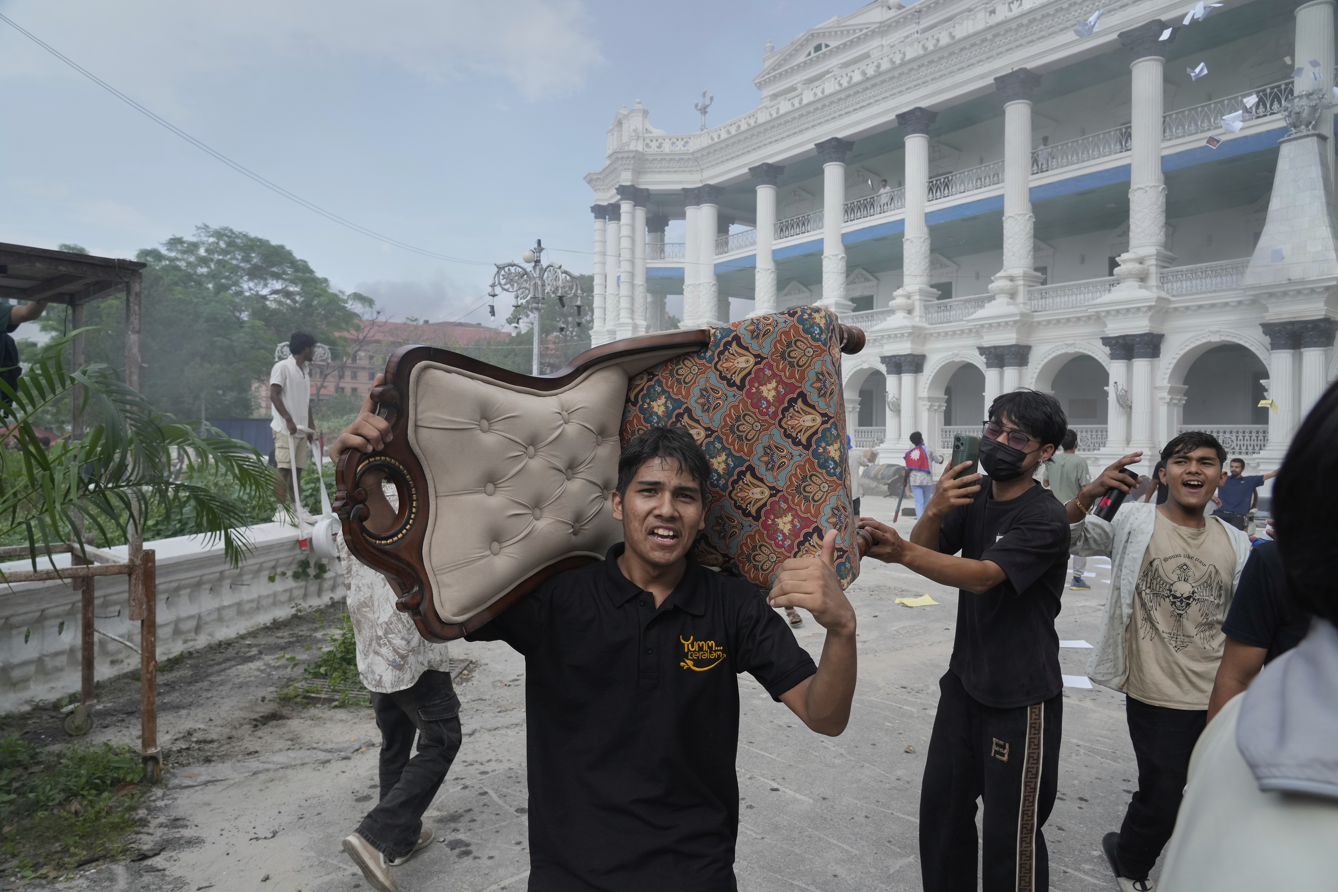 A protester carries a chair from the Singha Durbar, the seat of Nepal's government's various ministries and offices during a protest against social media ban and corruption in Kathmandu, Nepal, Tuesday, Sept. 9, 2025. (Niranjan Shrestha - AP)