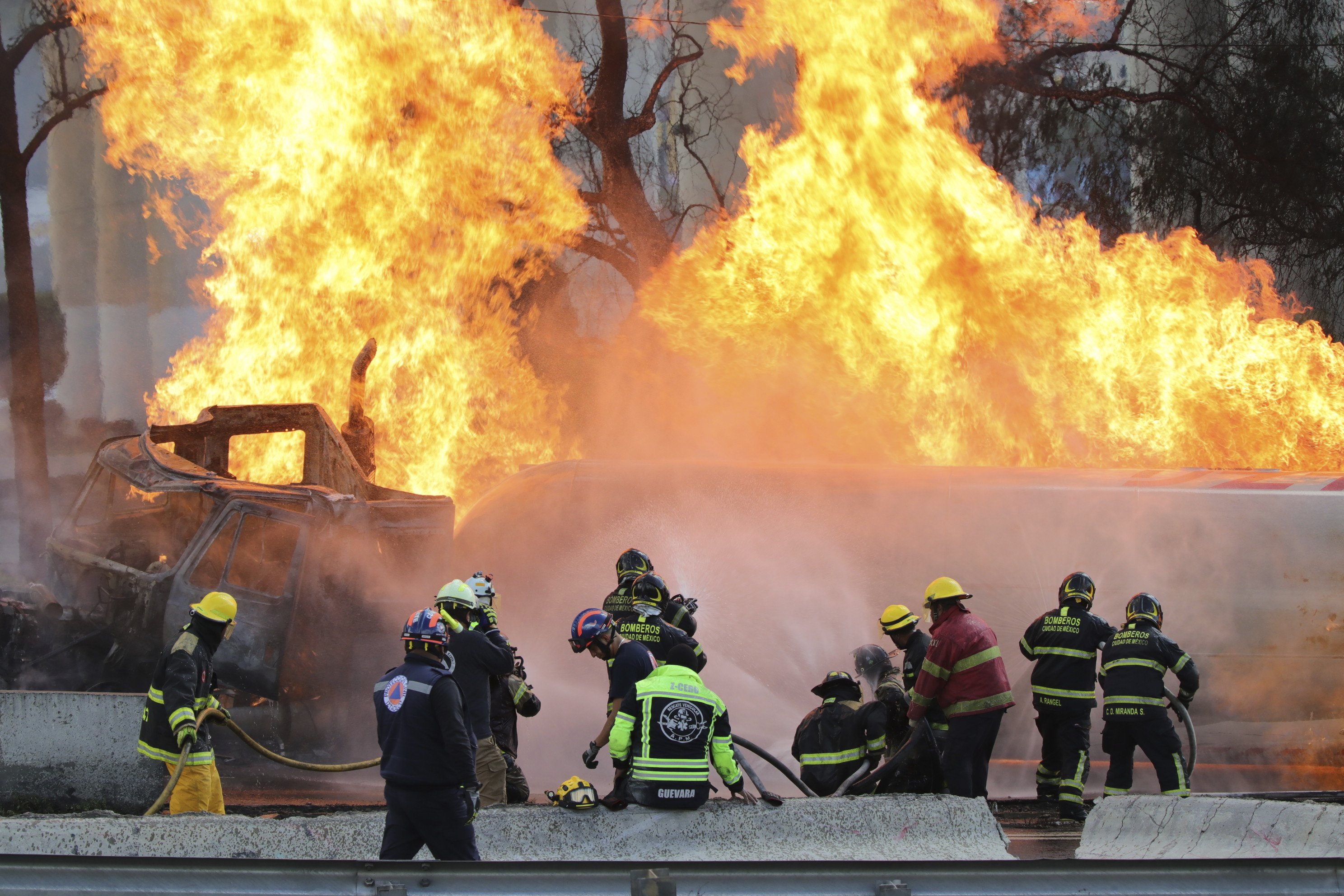 Firefighters spray hoses at a gas tanker that exploded under a highway overpass in Mexico City, Wednesday, Sept. 10, 2025. (Tristan Velazquez - AP)