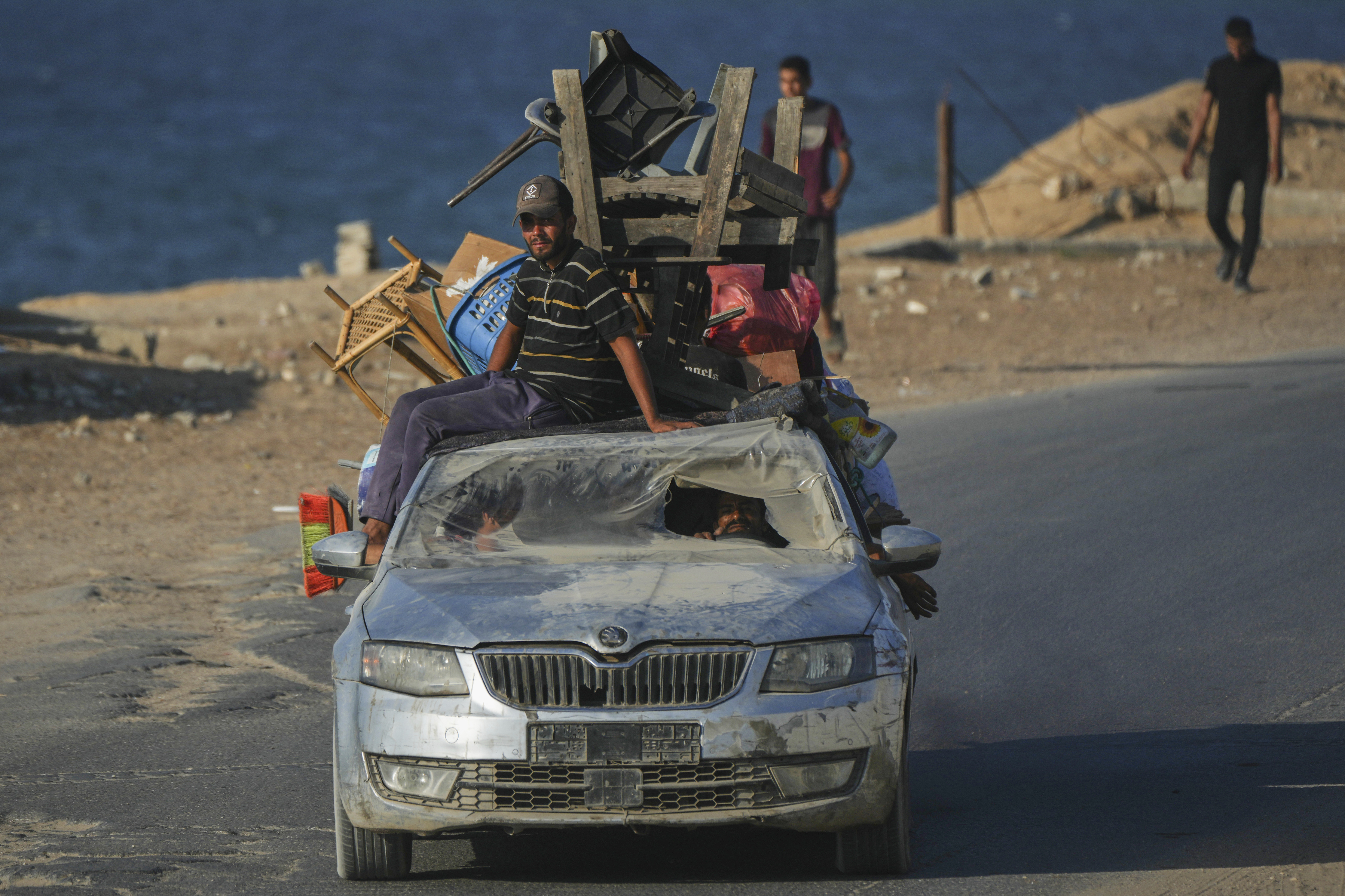 Displaced Palestinians fleeing northern Gaza carry their belongings in a car along the coastal road toward southern Gaza, Friday, Sept. 5, 2025. (Jehad Alshrafi - AP)