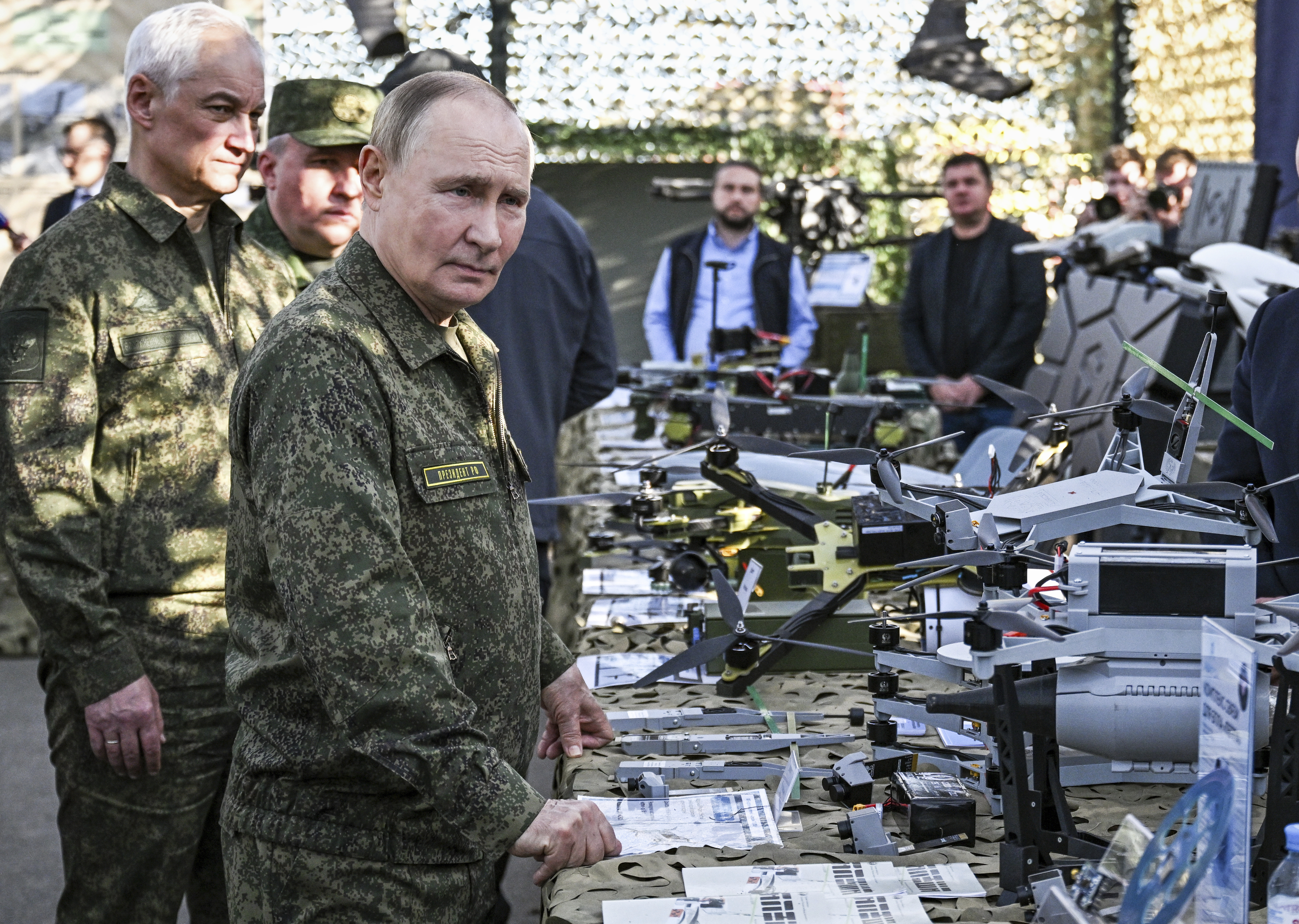 CORRECTS SOURCE FOR POOL - Russian President Vladimir Putin accompanied by Defence Minister Andrei Belousov, left, inspects Russian weapons and equipment during his visit to the Russian-Belarusian joint military drills 