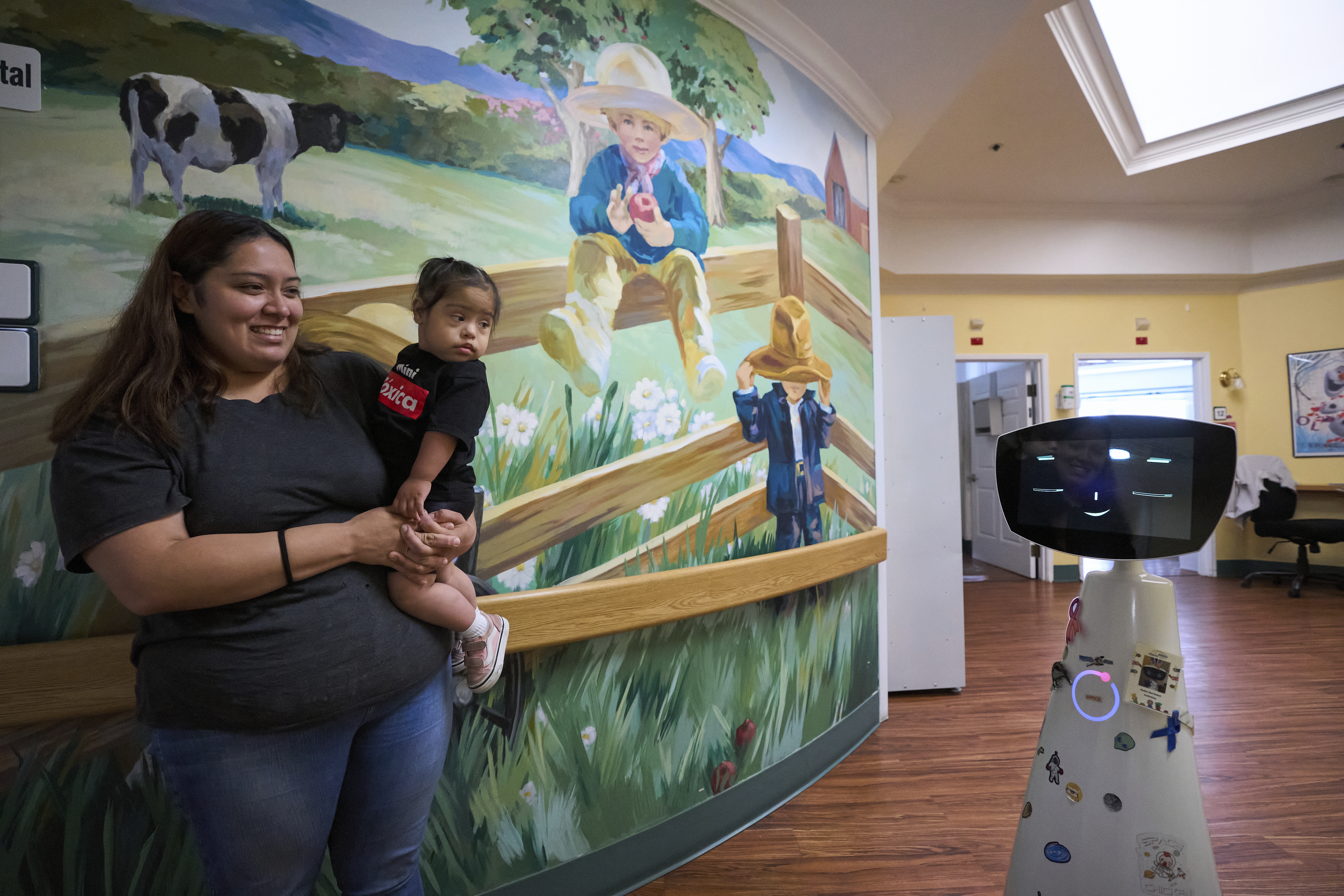Robin the Robot, developed by Expper Technologies, interacts with Erica Ruiz and her daughter, Valentina, at the HealthBridge Orange Specialty Pediatric Hospital in Orange, Calif., on Friday, Sept. 12, 2025. (Damian Dovarganes - AP)