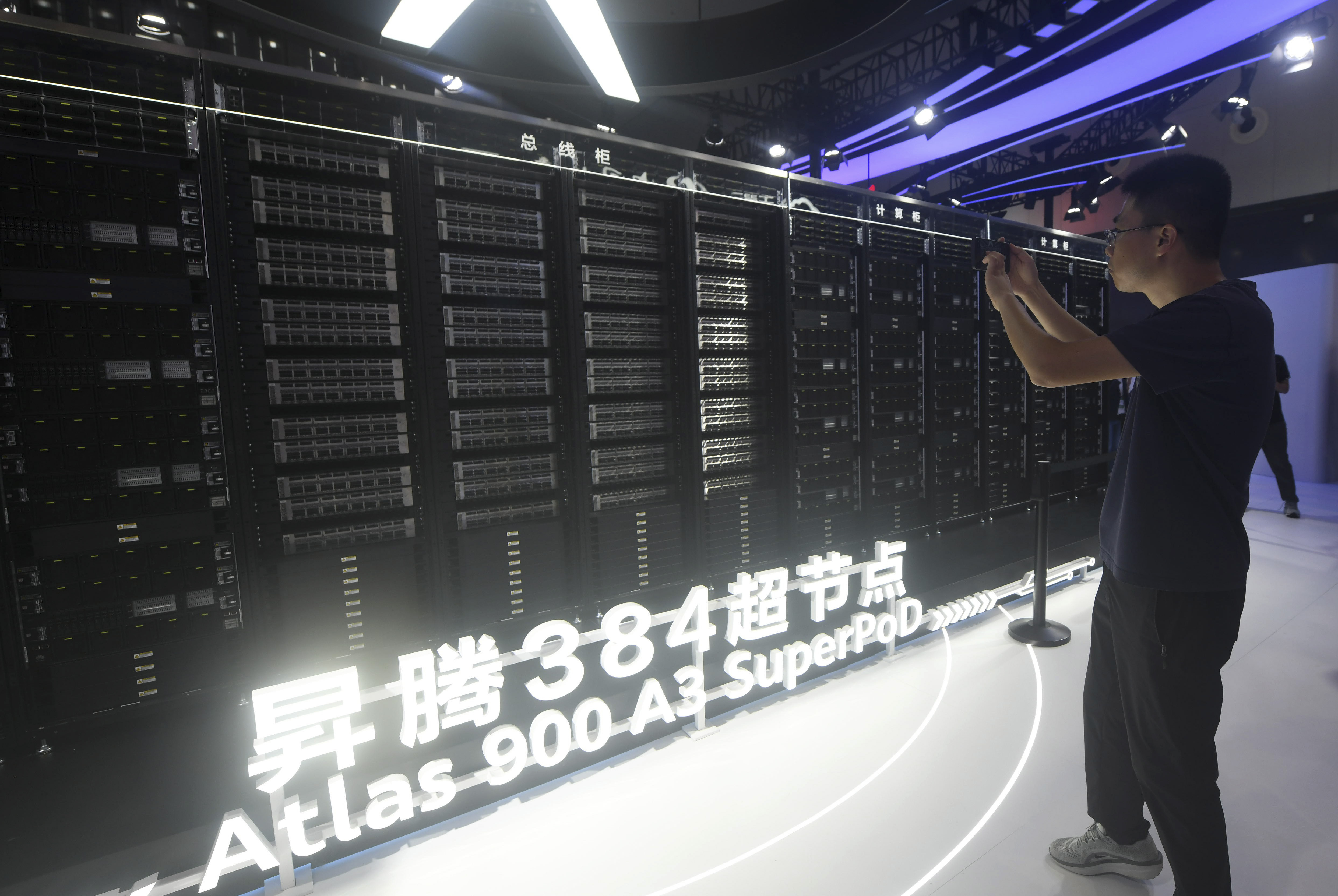 A visitor takes photos of the Huawei Atlas 900 A3 SuperPoD exhibited at the World Artificial Intelligence Conference in Shanghai, China, July 26, 2025. CHINA OUT (Uncredited - CHINATOPIX)