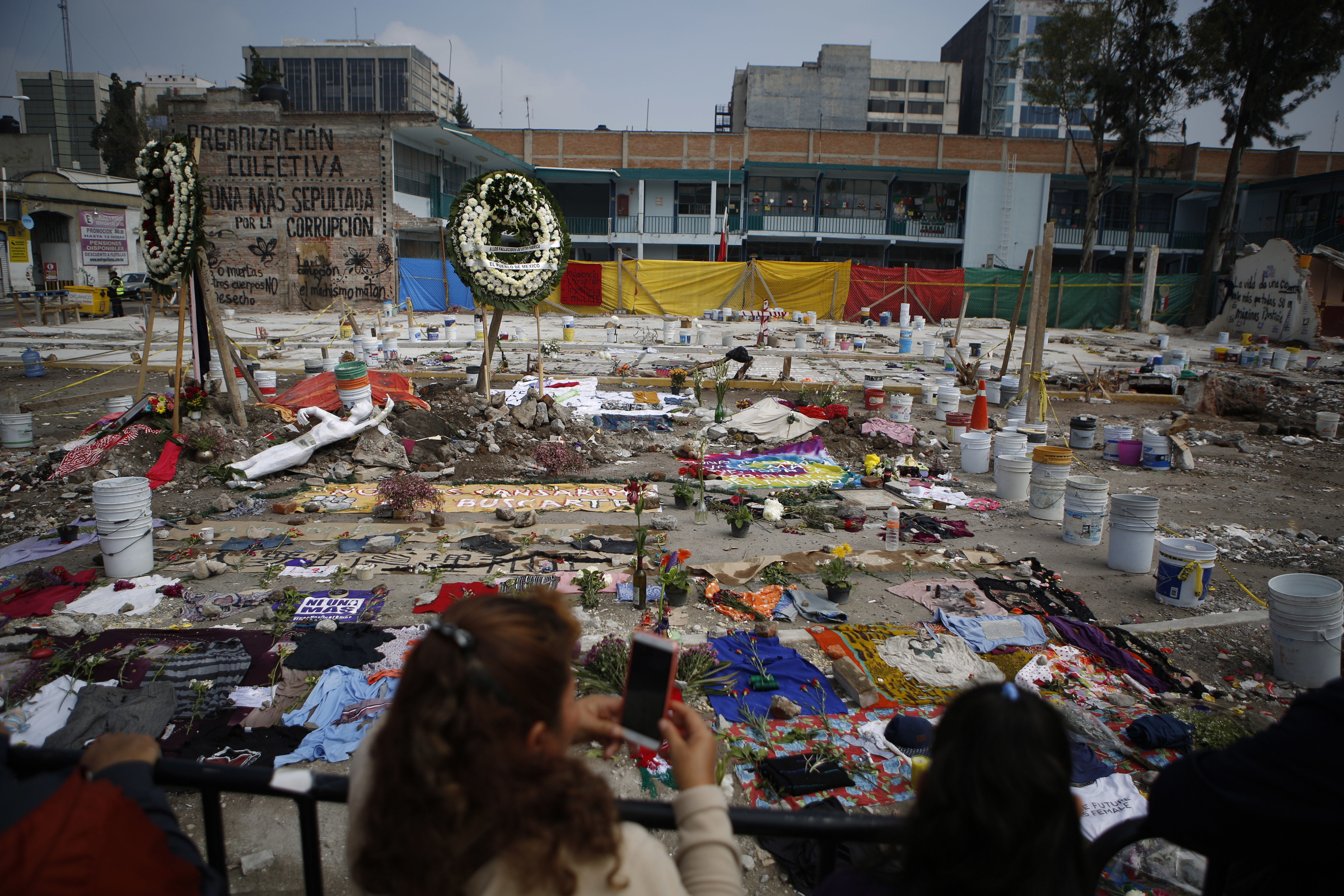 FILE - Clothing, cloth, and flowers are arranged in a memorial that includes the messages in Spanish: