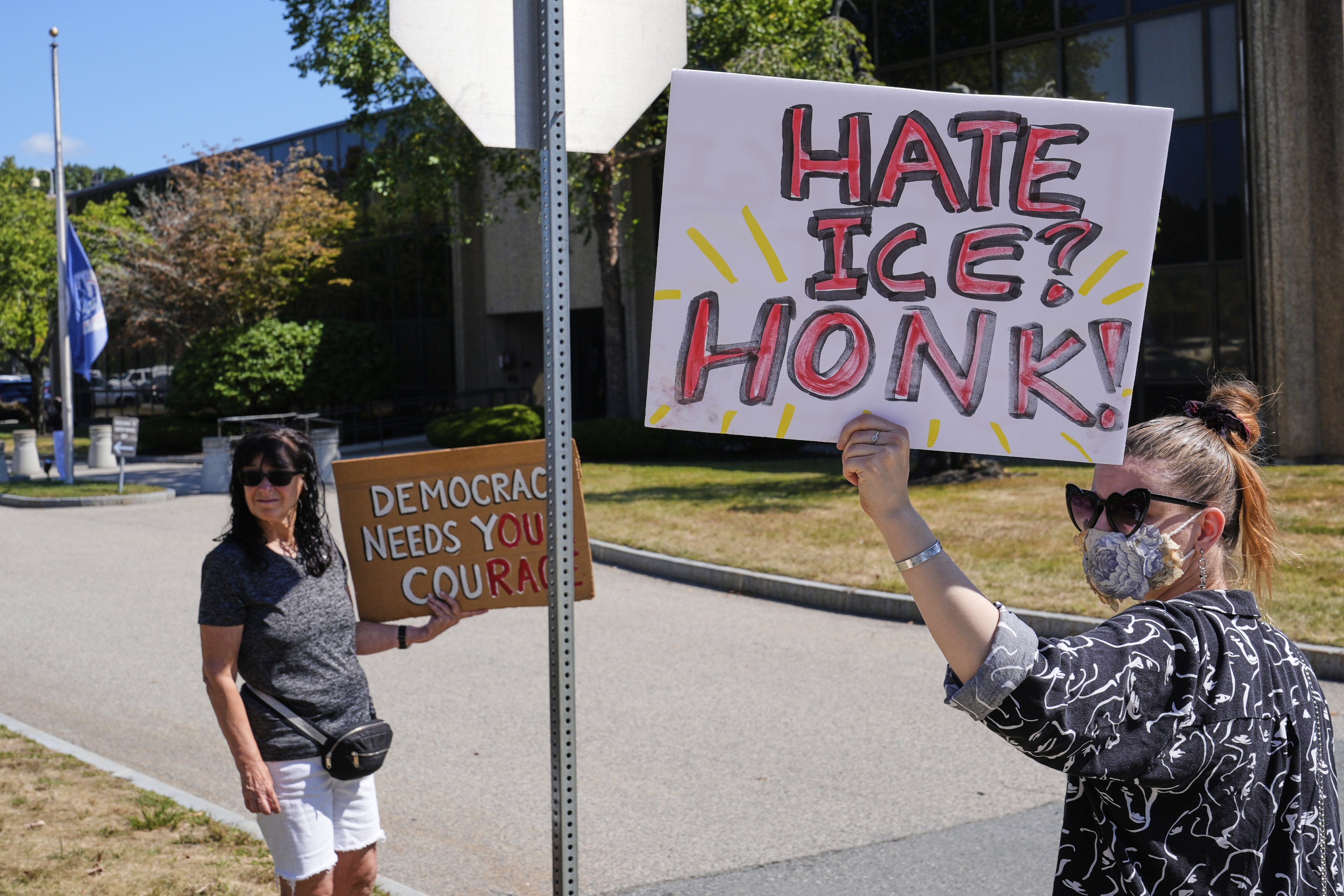 Protesters picket outside the U.S. Immigration and Customs Enforcement regional field office, at rear, Thursday, Sept. 11, 2025, in Burlington, Mass. (Charles Krupa - AP)