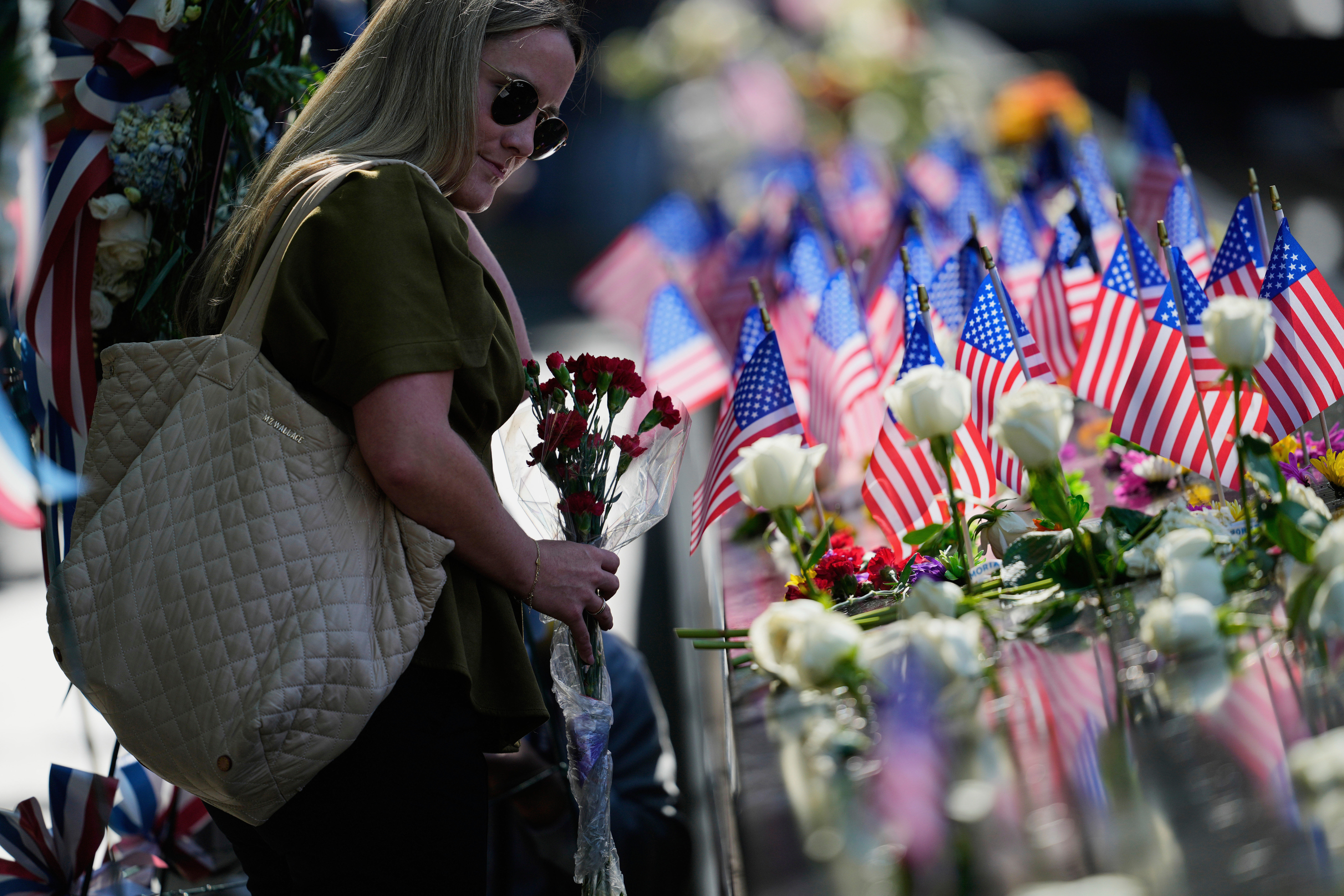 Jaclyn O'Connor places flowers on the 9/11 Memorial during a ceremony to mark the 24th anniversary of the 9/11 attacks, Thursday, Sept. 11, 2025, in New York. (Seth Wenig - AP)