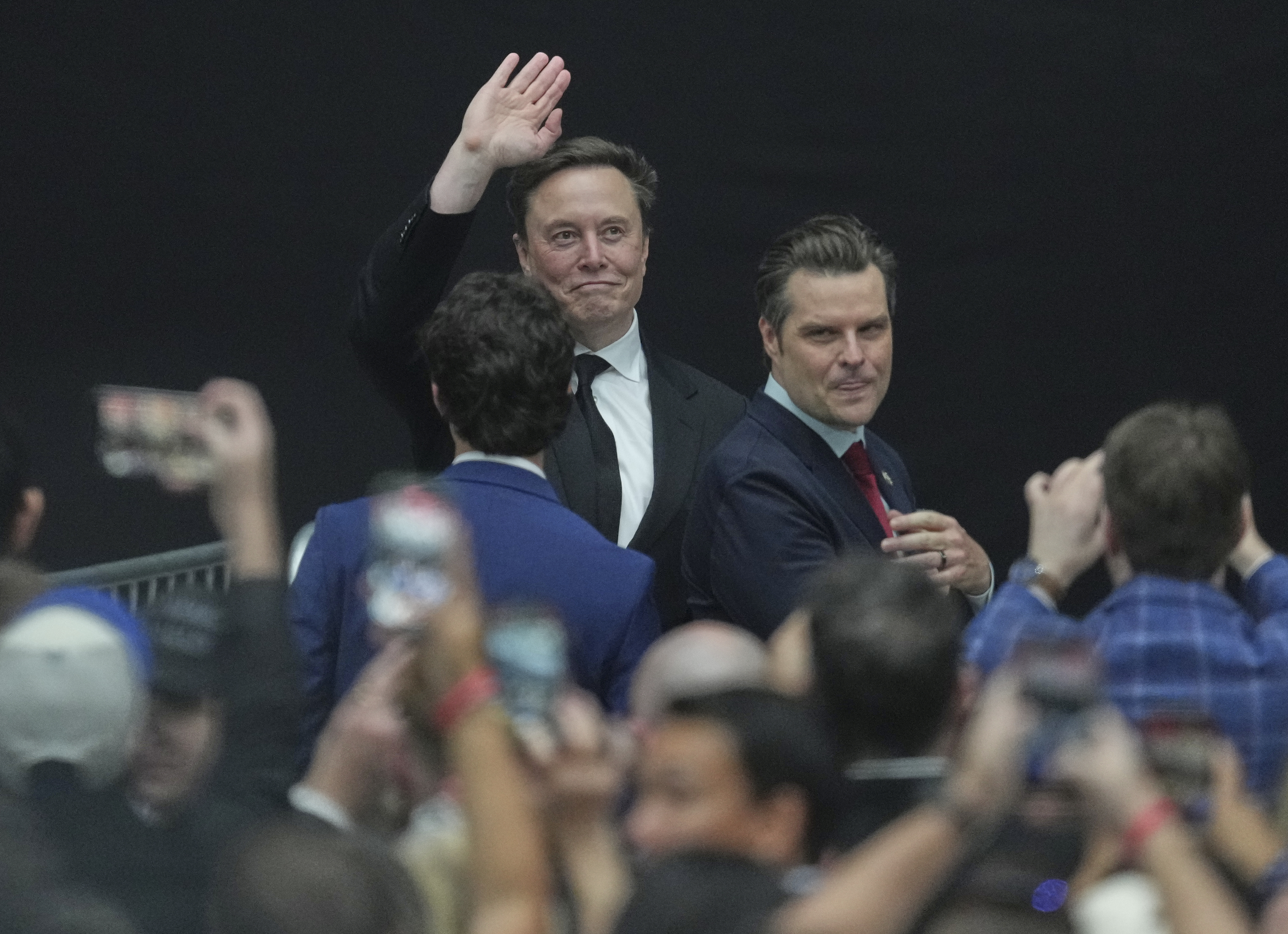 Elon Musk, left, waves to supporters alongside former Rep. Matt Gaetz during a memorial for Charlie Kirk, Sunday, Sept. 21, 2025, at State Farm Stadium in Glendale, Ariz. (Ross D. Franklin - AP)