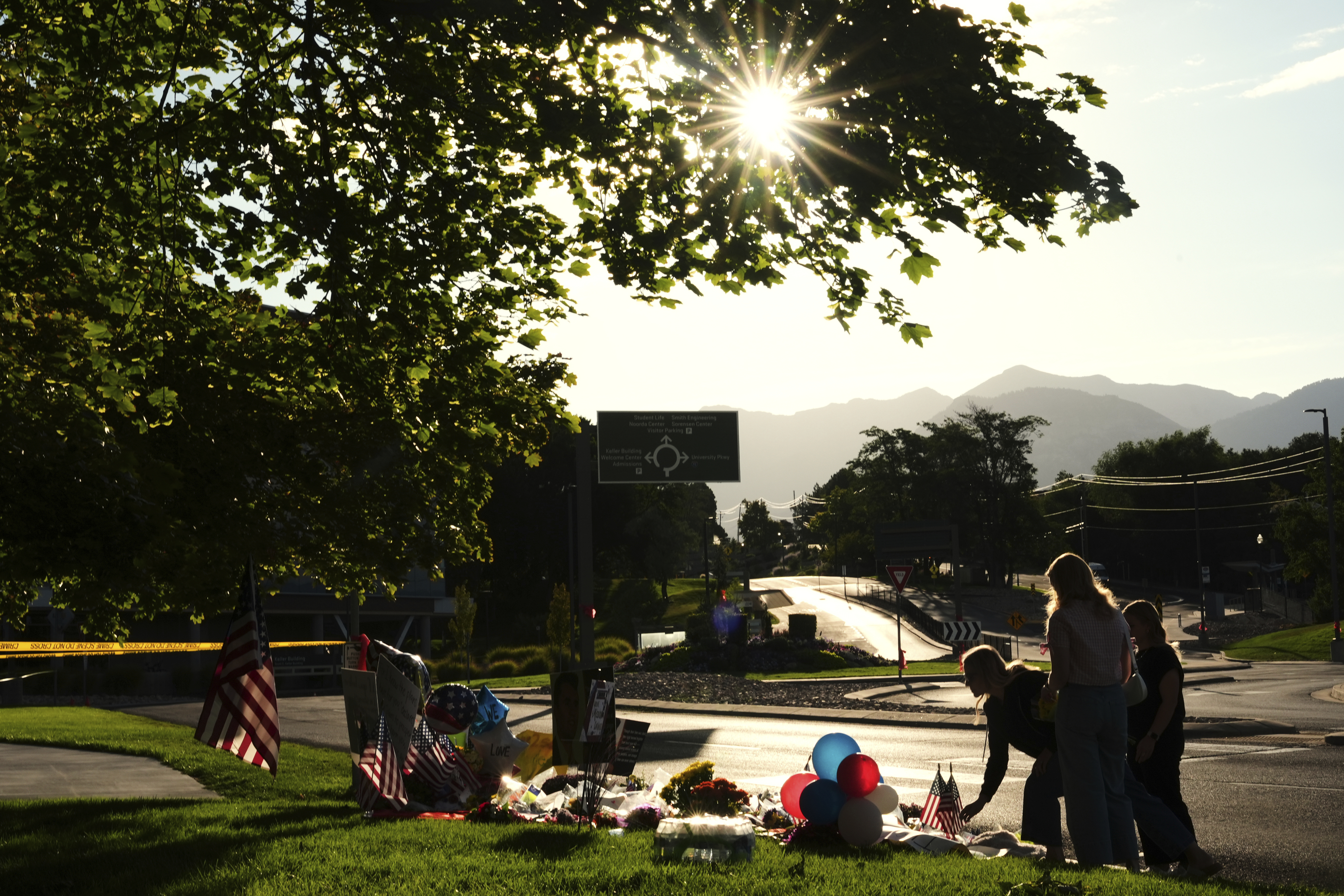 Women place flowers at a memorial outside Utah Valley University after Turning Point USA CEO and co-founder Charlie Kirk was shot and killed, Saturday, Sept. 13, 2025, in Orem, Utah. (Lindsey Wasson - AP)