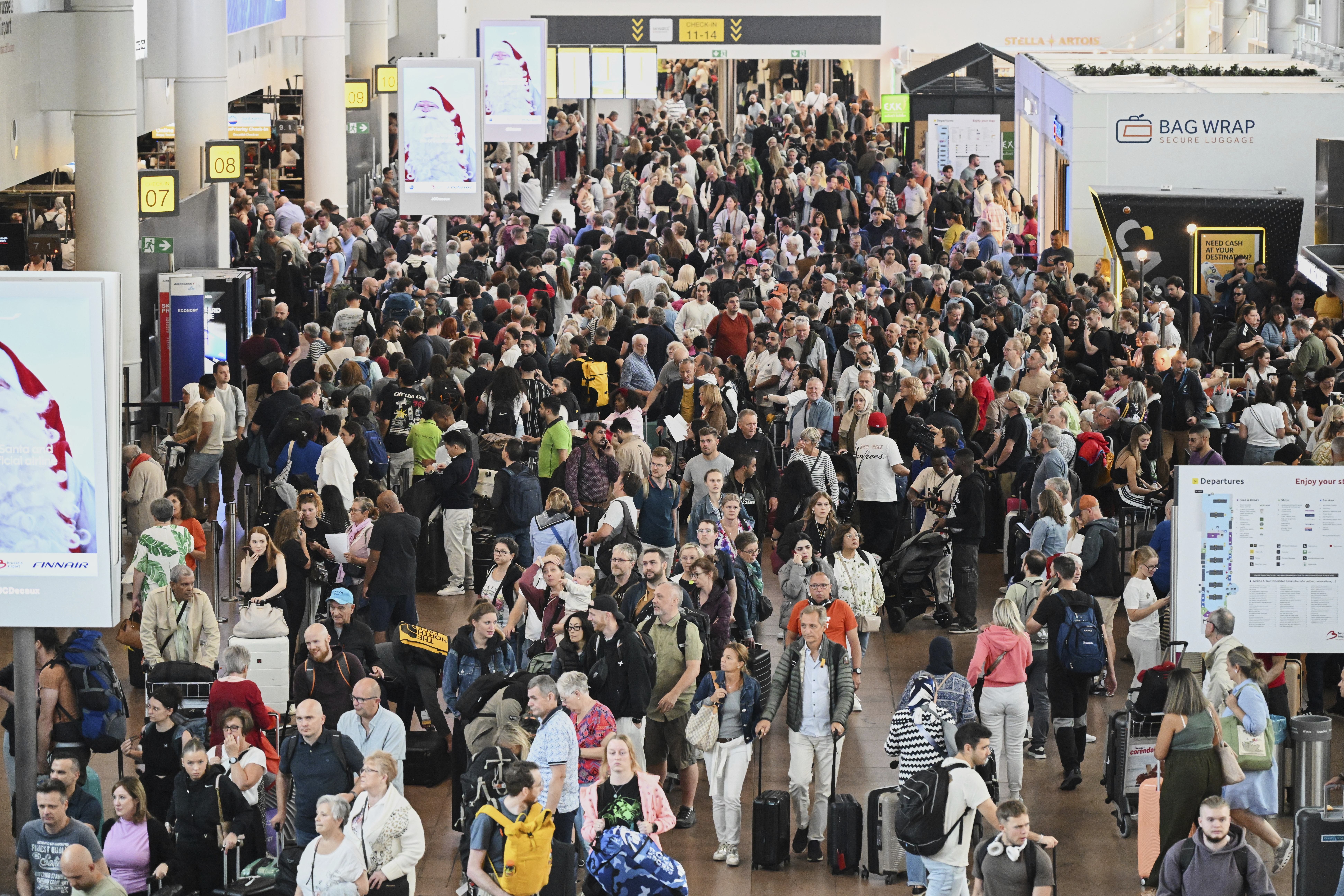People walk by a departures board after a cyber attack caused delays at Brussels International Airport in Zaventem, Belgium, Saturday, Sept. 20, 2025. (Harry Nakos - AP)