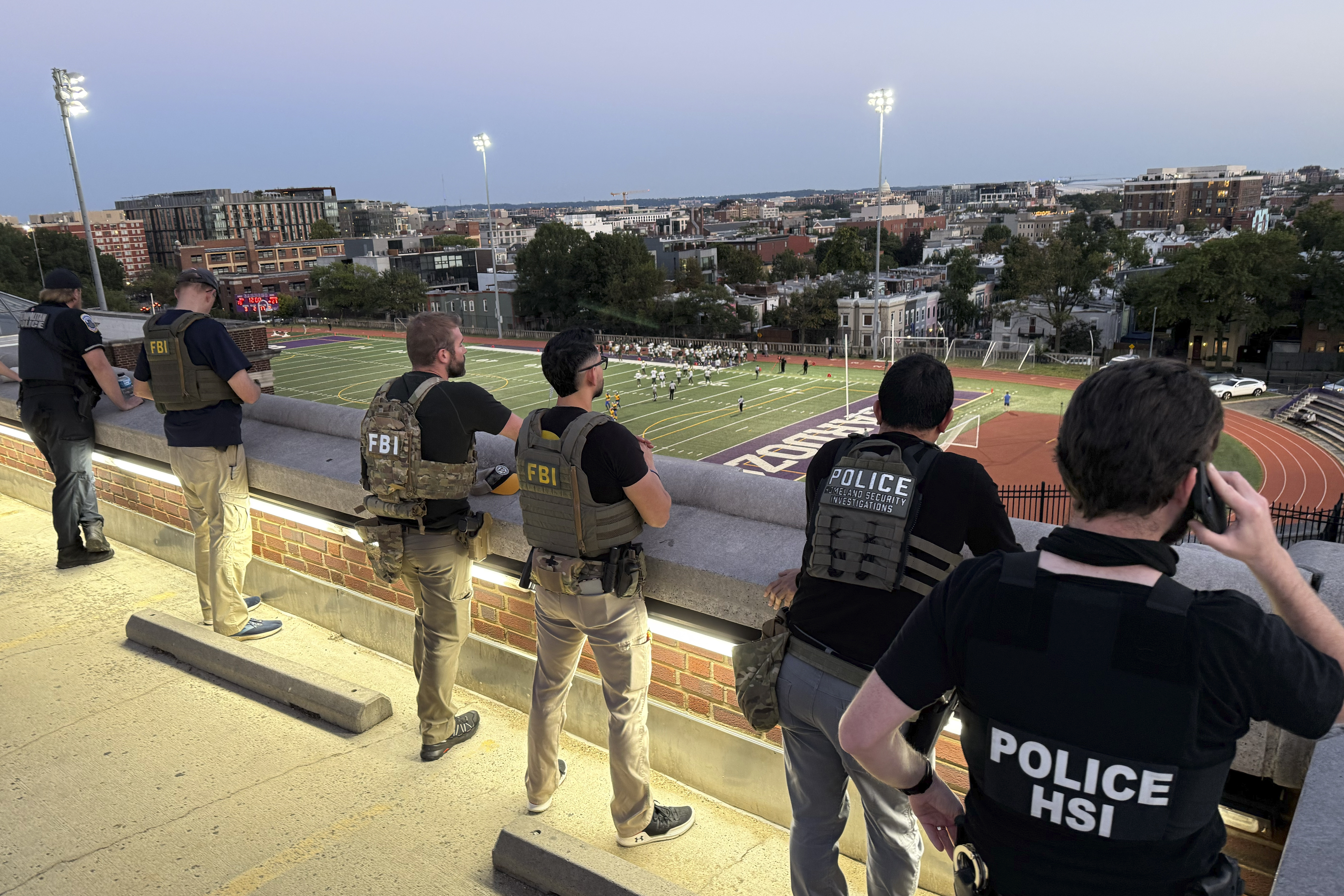 Officers from Metropolitan Police Department, FBI, and Homeland Security Investigations (HSI), are seen monitoring a football game between Bell Multicultural and Archbishop Carroll, Friday, Sept., 12, 2025, at Cardozo High School in the Columbia Heights neighborhood in Washington. (Pablo Martinez Monsivais - AP)