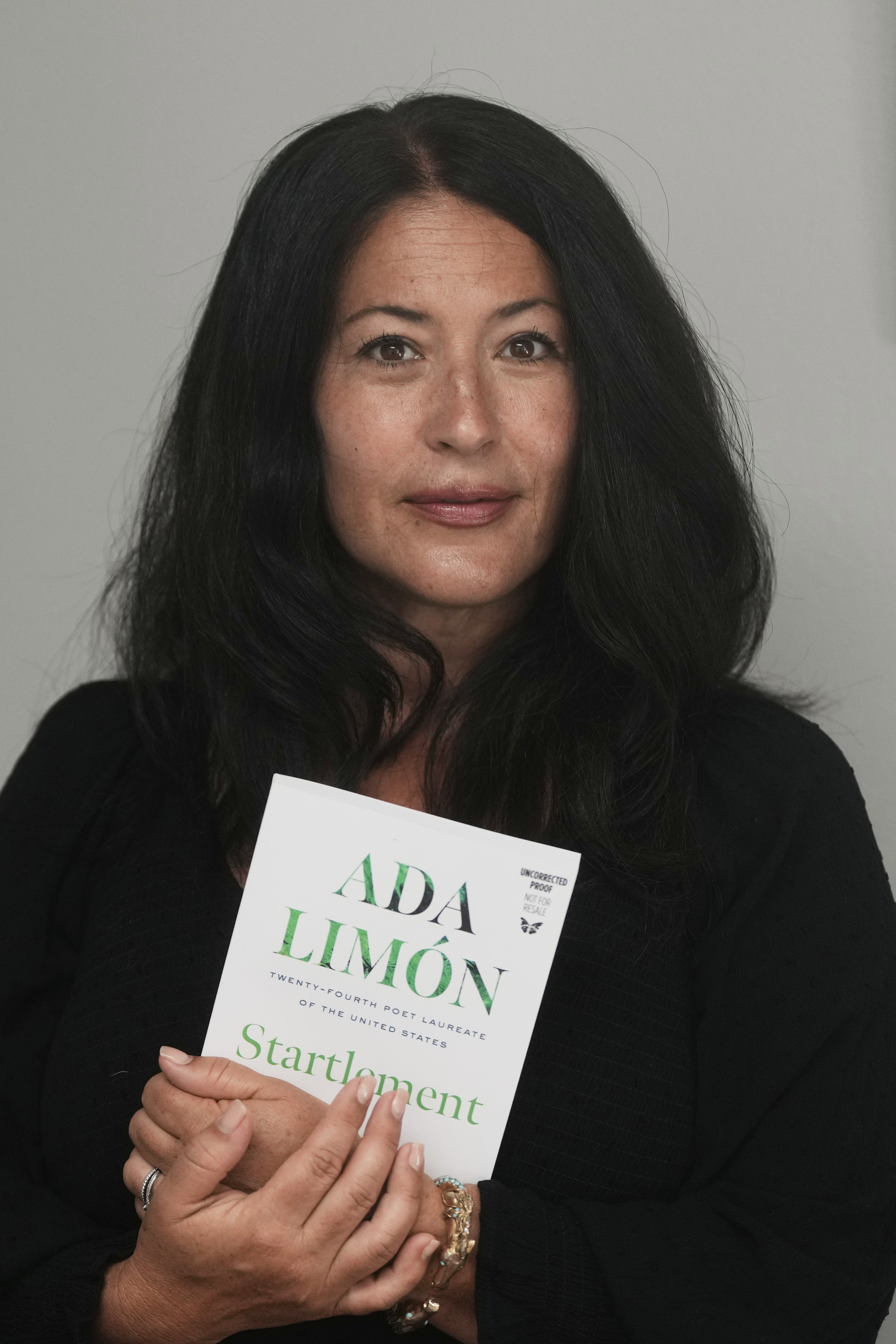 Ada Limón, 24th Poet Laureate of the United States, poses with a copy of her book