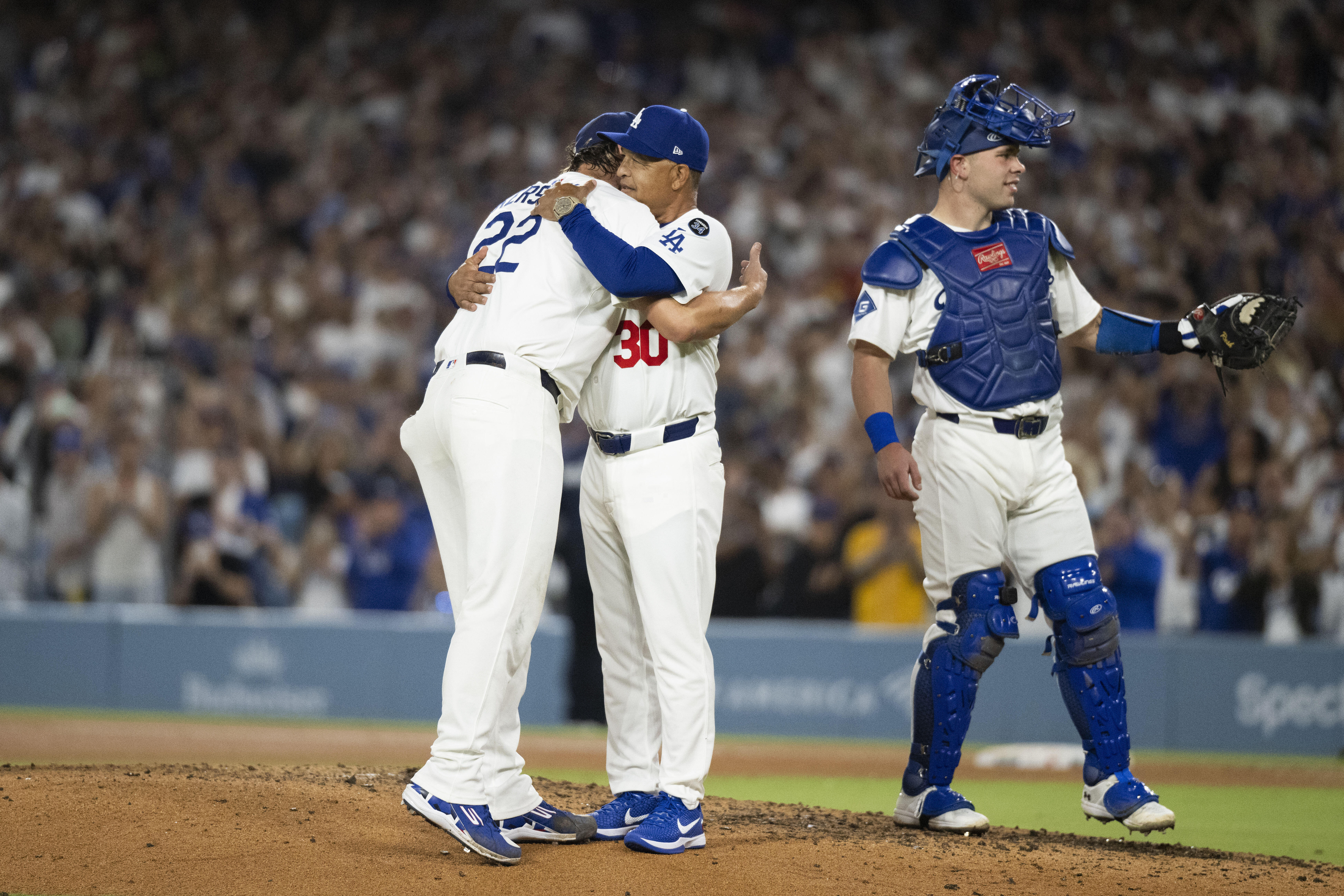 Los Angeles Dodgers starting pitcher Clayton Kershaw, left, hugs manager Dave Roberts, center, after being removed during the fifth inning of a baseball game against the San Francisco Giants, in Los Angeles, Friday, Sept. 19, 2025. (Kyusung Gong - FR171561 AP)