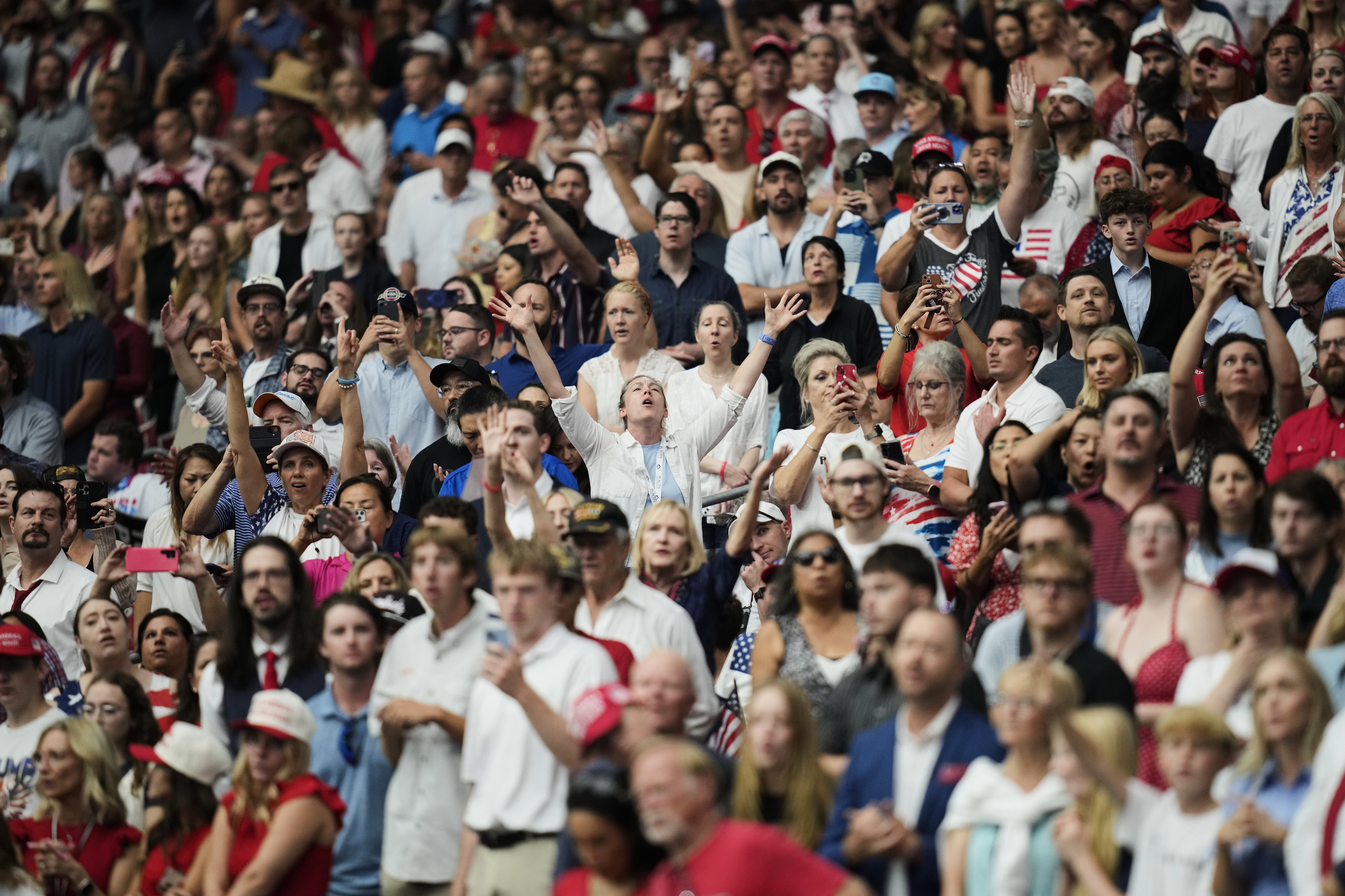 People listen during a worship song before the start of a memorial for conservative activist Charlie Kirk, Sunday, Sept. 21, 2025, at State Farm Stadium in Glendale, Ariz. (John Locher - AP)