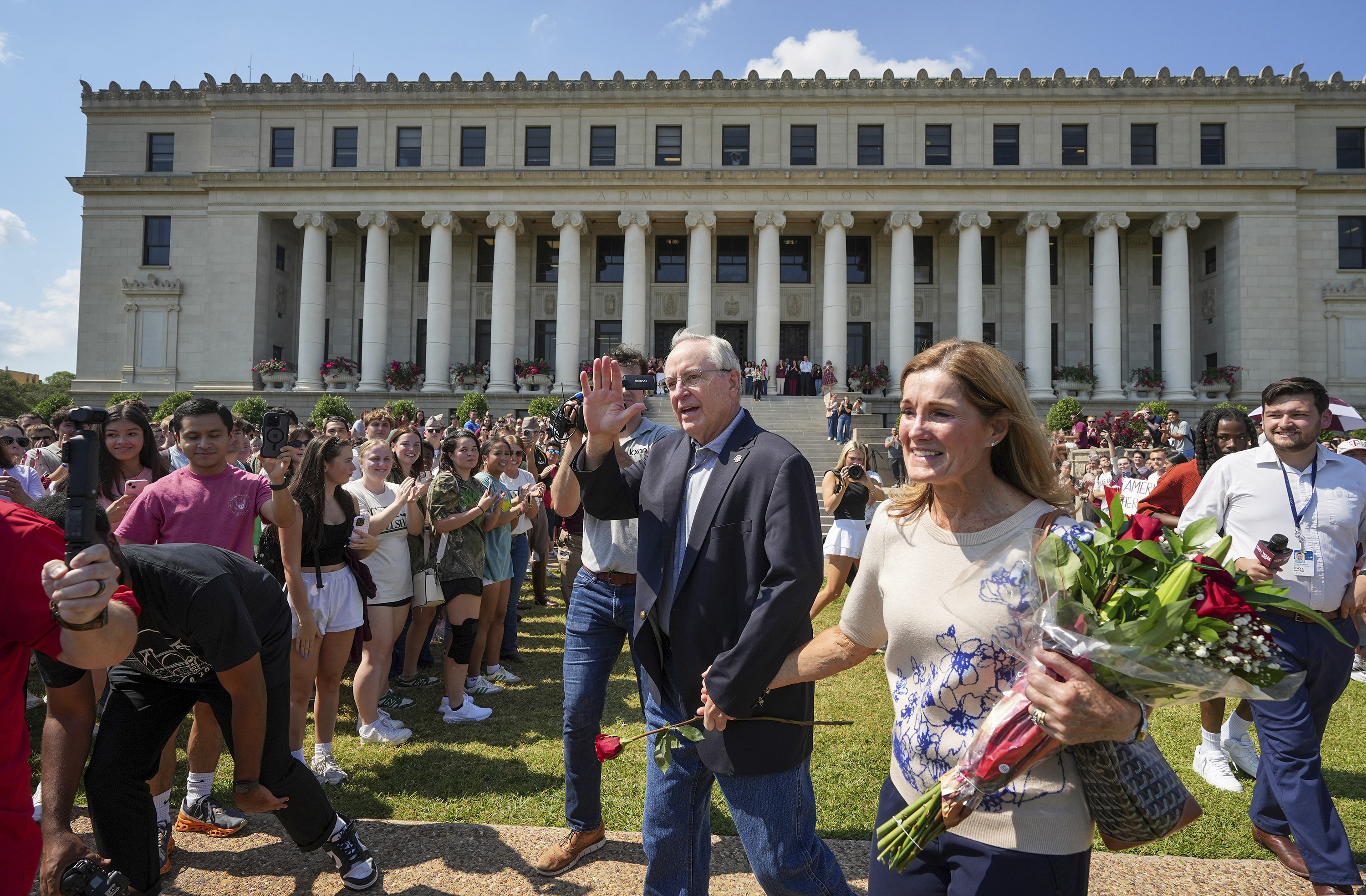 Texas A&M University President Mark Welsh, center, accompanied by his wife, Betty, exits the administration building after resigning in College Station, Texas, on Friday, Sept. 19, 2025. (Jay Janner - Austin American-Statesman)