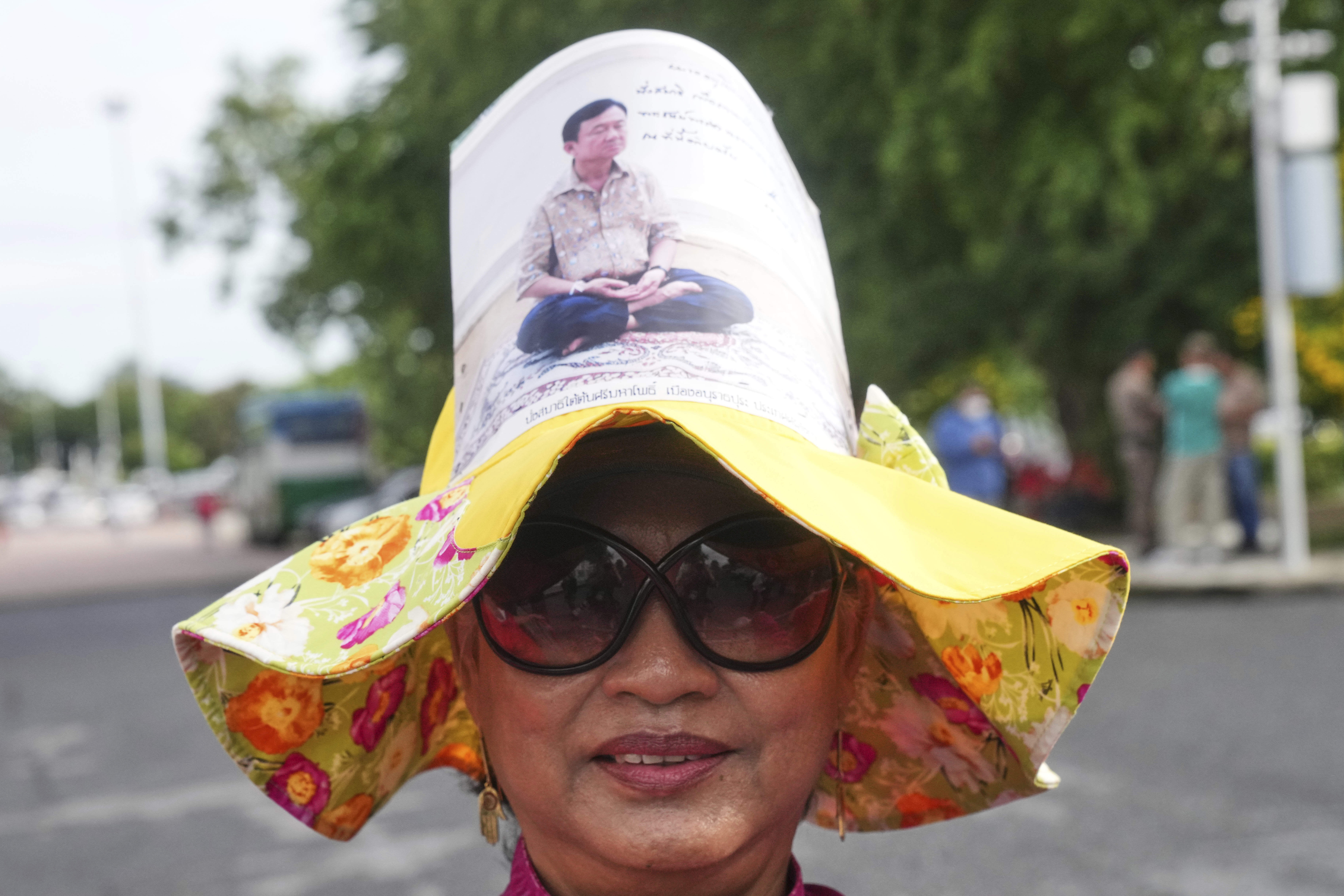 A supporter of Thailand's former Prime Minister Thaksin Shinawatra wears a hat with his image on, outside the Supreme Court in Bangkok, Thailand, Tuesday, Sept. 9, 2025, (Sakchai Lalit - AP)