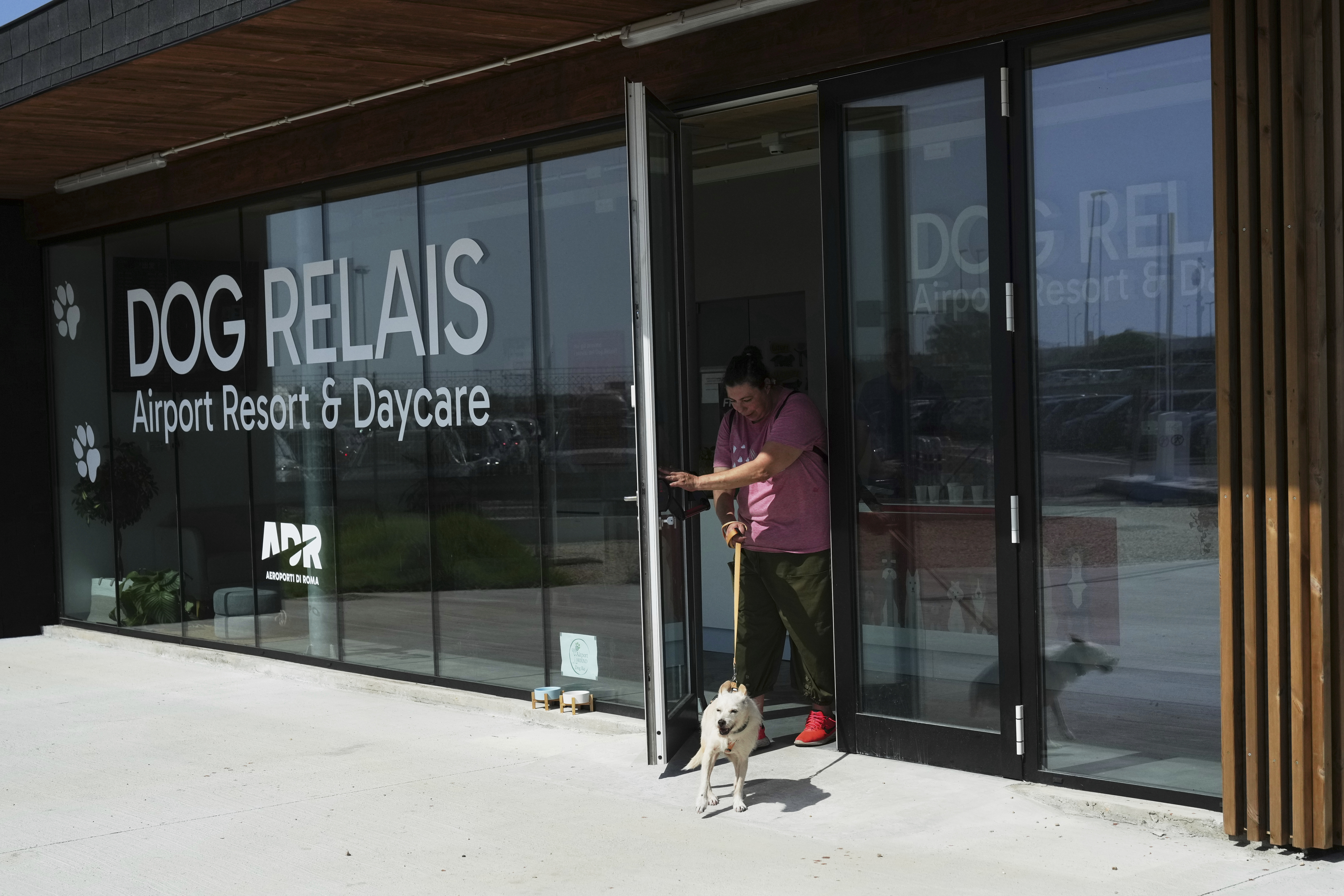 A costumer walks with her dog as she leaves the Dog Relais, a hotel for dogs at Rome's Fiumicino International Airport, Wednesday, Sept. 17, 2025. (Alessandra Tarantino - AP)