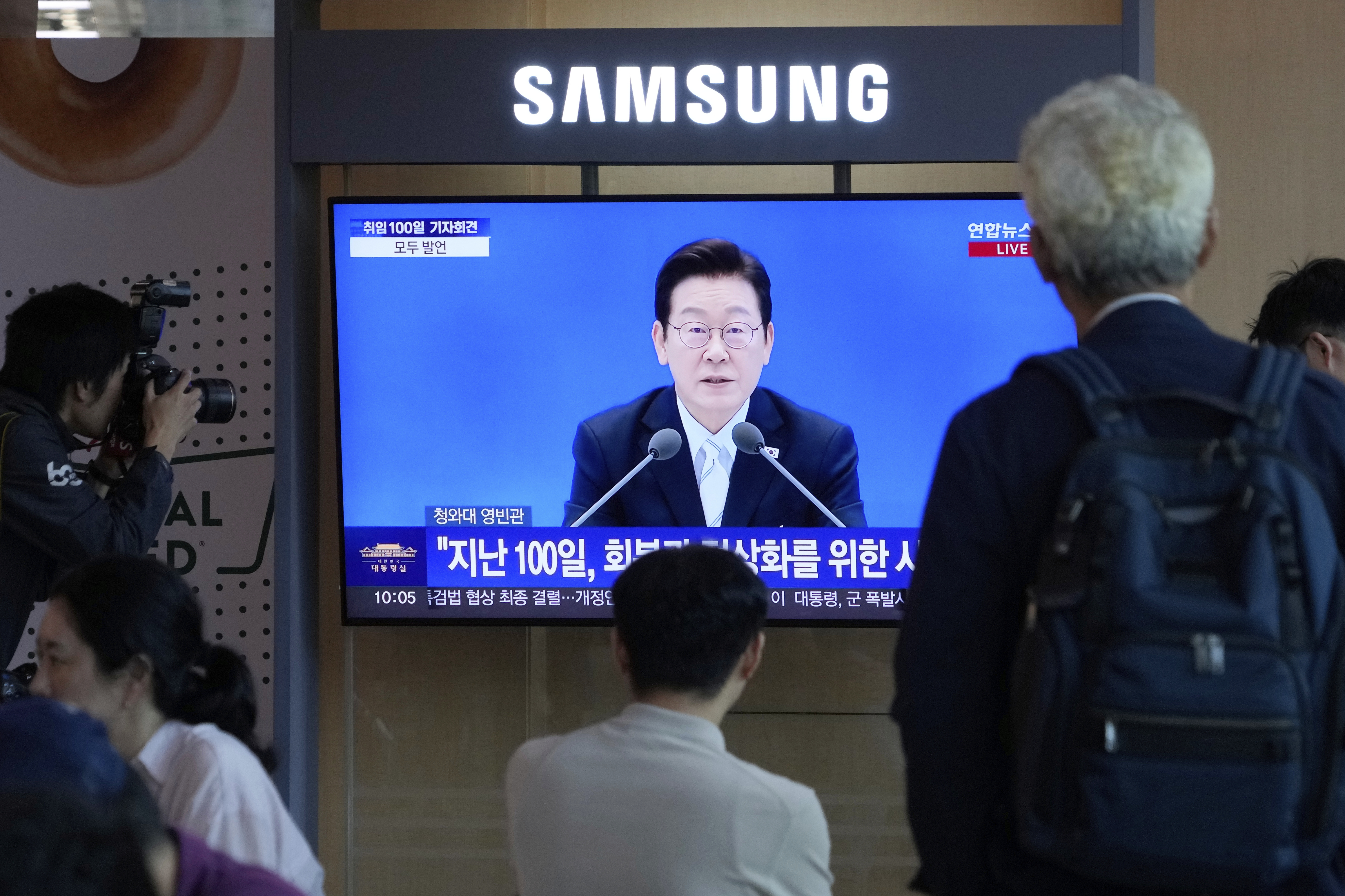 People watch a TV screen showing the live broadcast of South Korean President Lee Jae Myung's press conference at the Seoul Railway Station in Seoul, South Korea, Thursday, Sept. 11, 2025. (Ahn Young-joon - AP)
