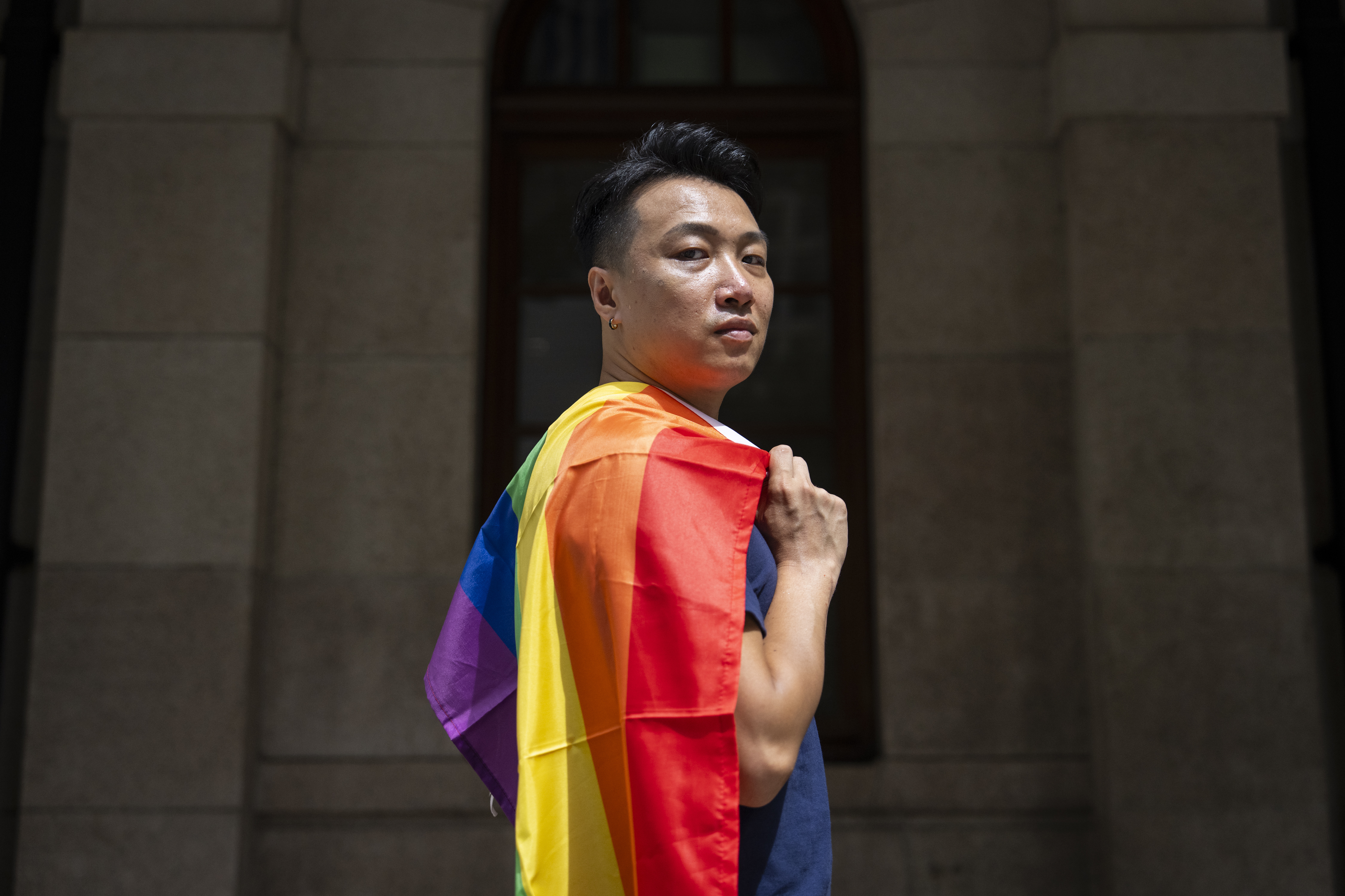Jimmy Sham, gay rights activist and former pro-democracy district councillor, holds rainbow flag as he poses for photographs in front of the court of final appeal in Hong Kong, Sunday, Aug. 24, 2025. (Chan Long Hei - AP)