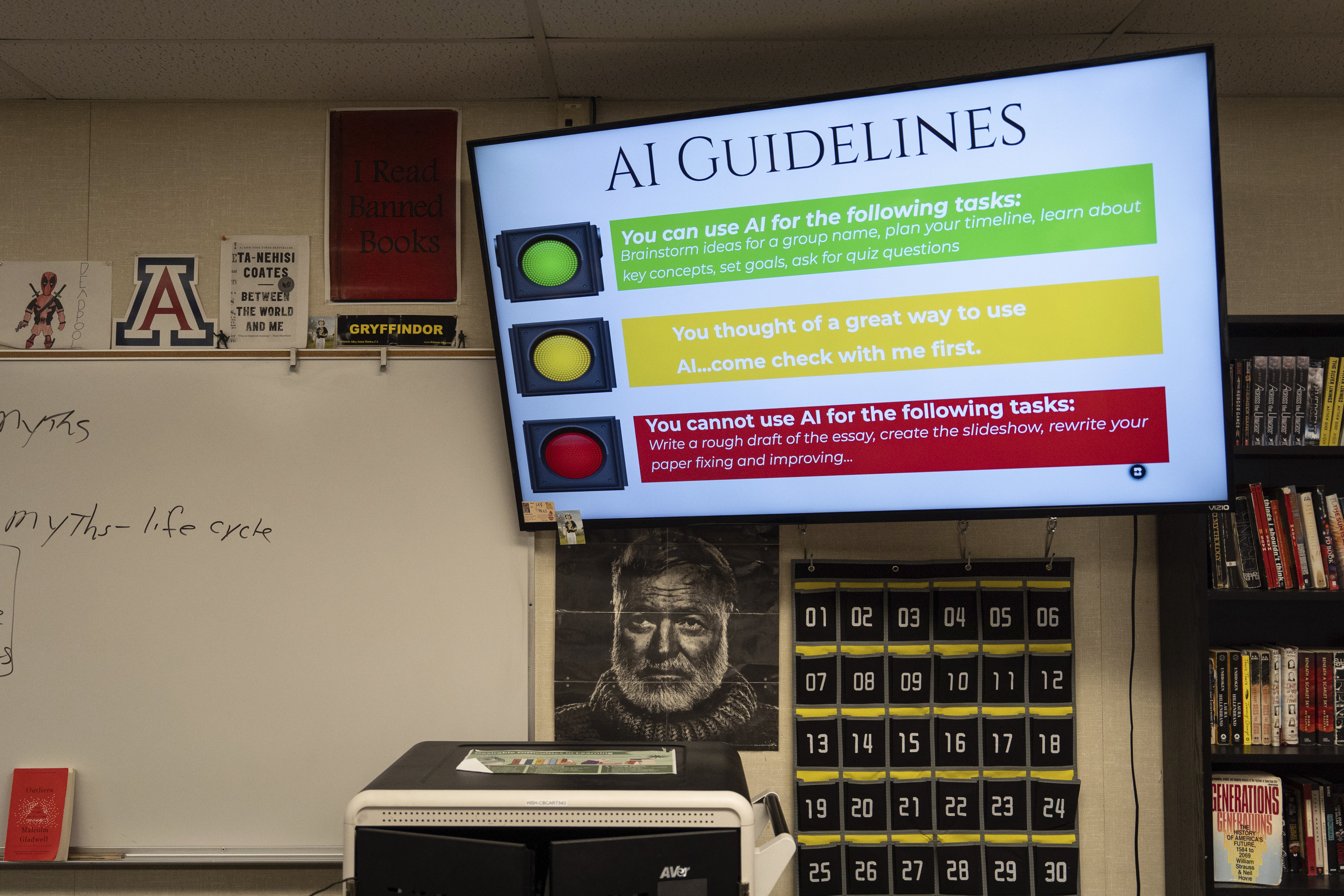 A screen displays guidelines for using artificial intelligence above a portrait of Ernest Hemingway in Casey Cuny's English class at Valencia High School in Santa Clarita, Calif., Wednesday, Aug. 27, 2025. (Jae C. Hong - AP)