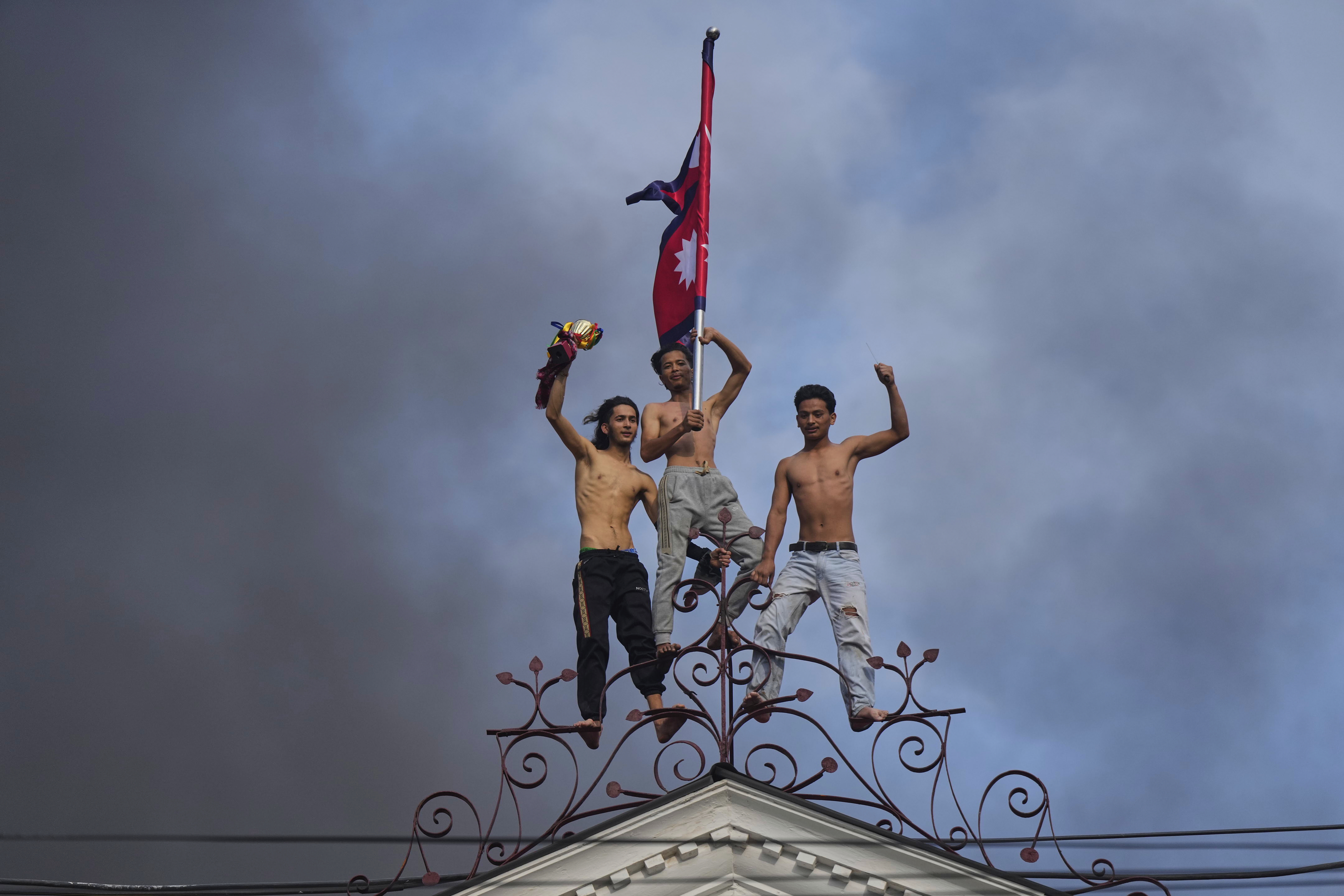 Protesters celebrate standing at the top of the Singha Durbar, the seat of Nepal's government's various ministries and offices, after it was set on fire during a protest against social media ban and corruption in Kathmandu, Nepal, Tuesday, Sept. 9, 2025. (Niranjan Shrestha - AP)