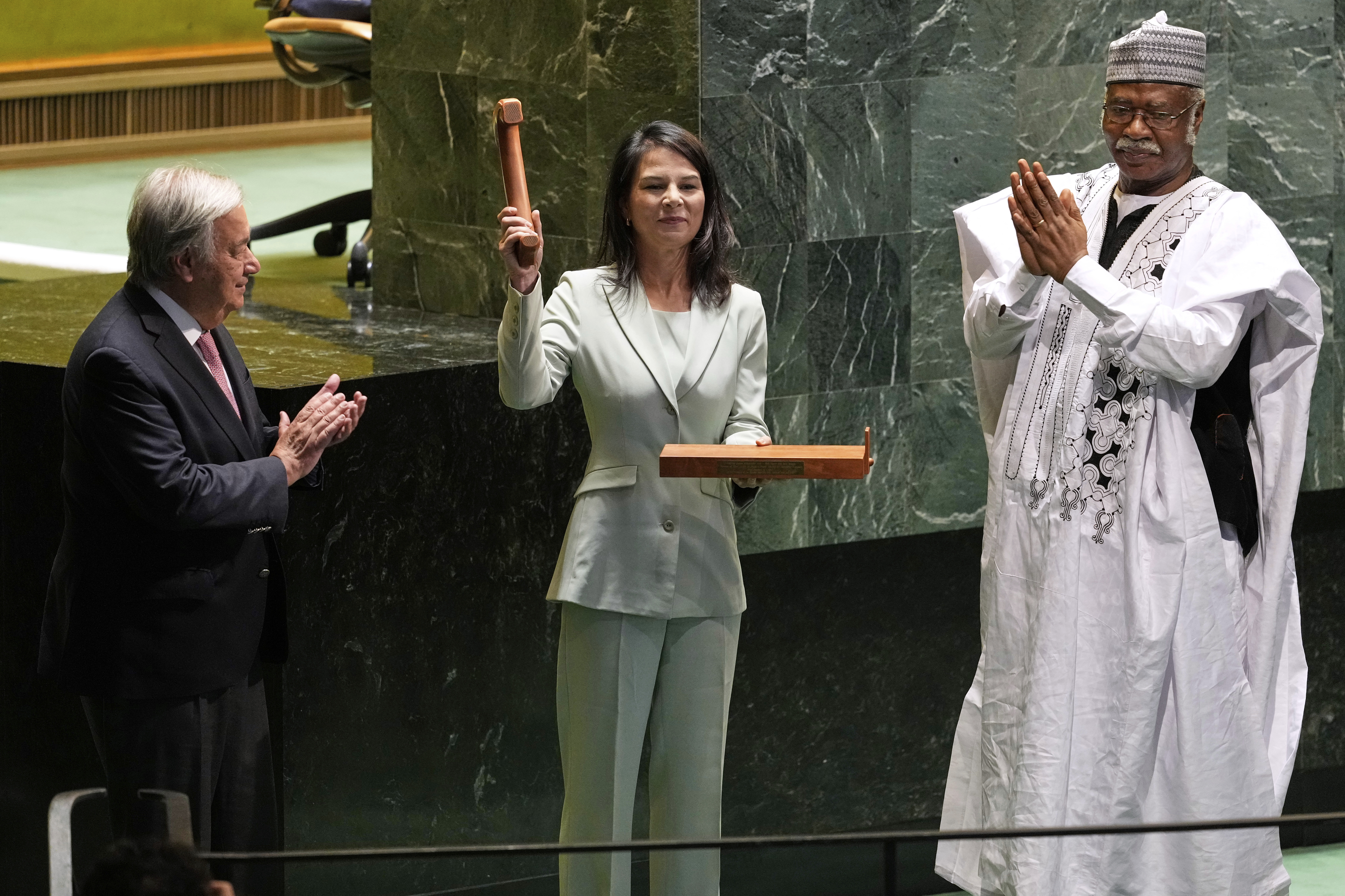 Secretary-General António Guterres, left, and former president of the General Assembly Philemon Yang, right, look on, as Annalena Baerbock, center, holds up a gavel after being sworn in as the president of the 80th session of the United Nations General Assembly at United Nations headquarters, Tuesday, Sept. 9, 2025. (Seth Wenig - AP)