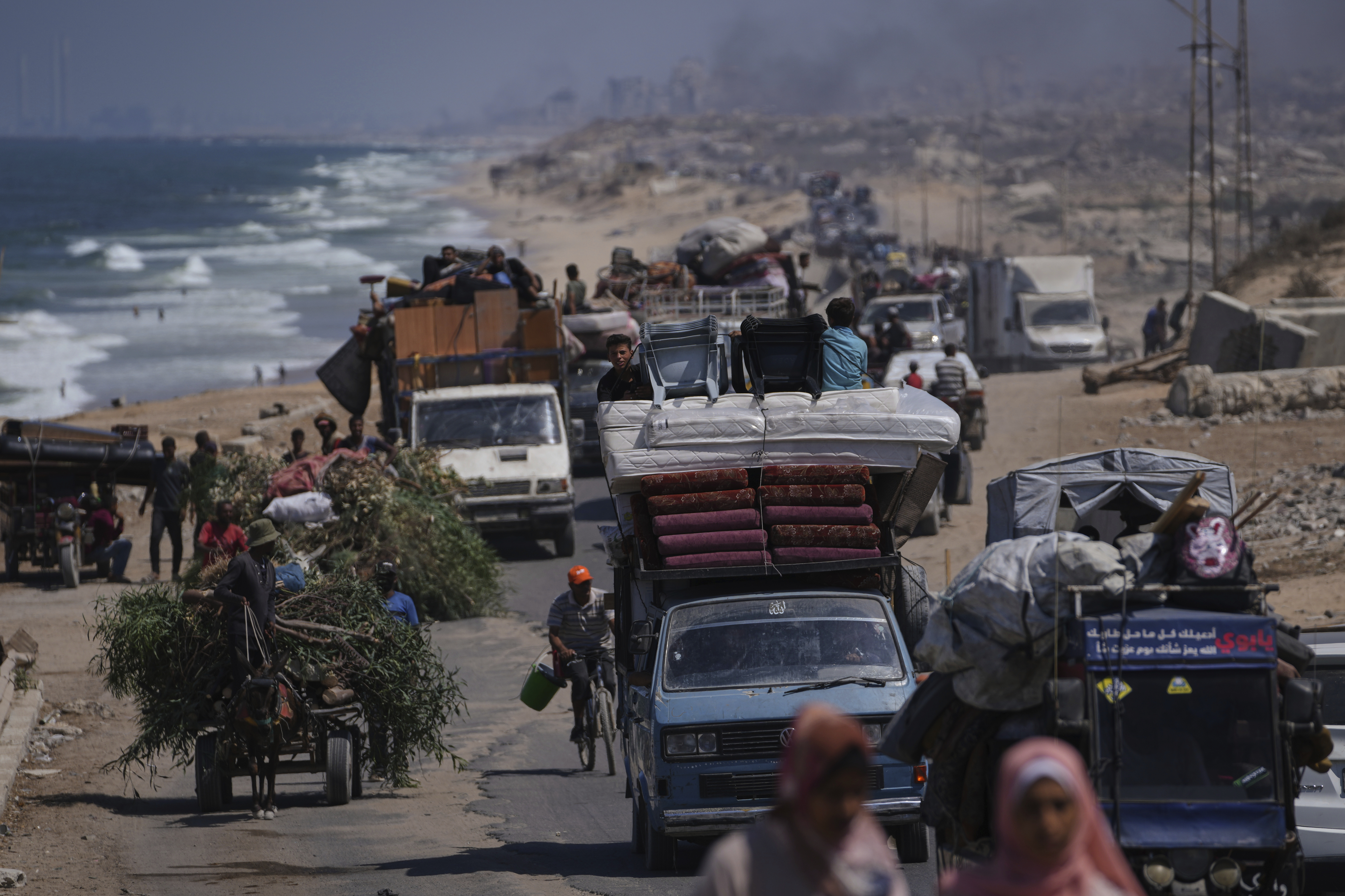 Displaced Palestinians fleeing northern Gaza carry their belongings along the coastal road toward southern Gaza, Tuesday, Sept. 9, 2025, after the Israeli army issued evacuation orders from Gaza City. (Jehad Alshrafi - AP)