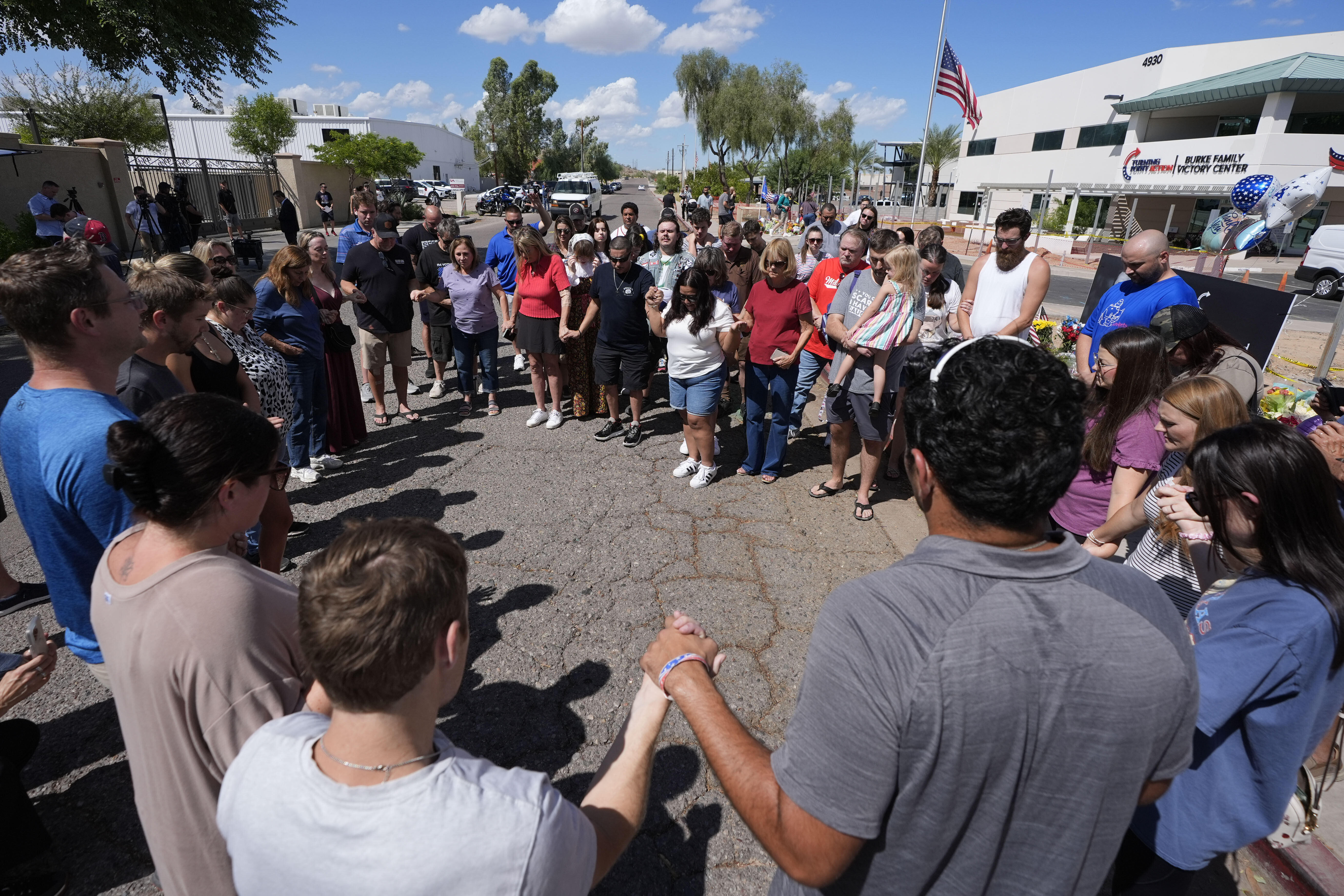Well-wishers pray at a makeshift memorial set up at Turning Point USA headquarters after the shooting death at a Utah college on Wednesday of Charlie Kirk, the 31-year-old founder and CEO of the organization, Thursday, Sept. 11, 2025, in Phoenix. (Ross D. Franklin - AP)