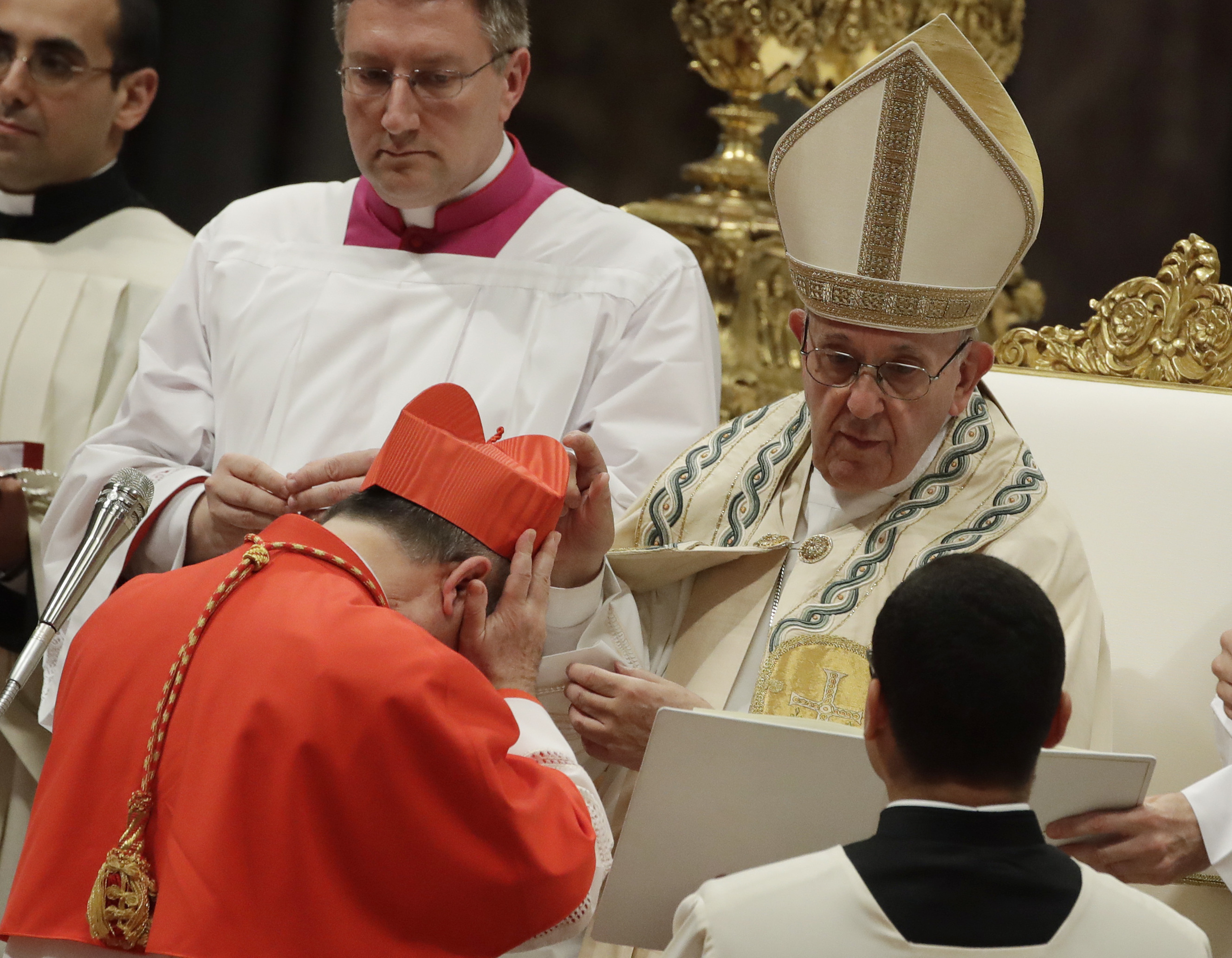 FILE - Cardinal Giovanni Angelo Becciu receives the red three-cornered biretta hat from Pope Francis during a consistory in St. Peter's Basilica at the Vatican, June 28, 2018. (Alessandra Tarantino - AP)