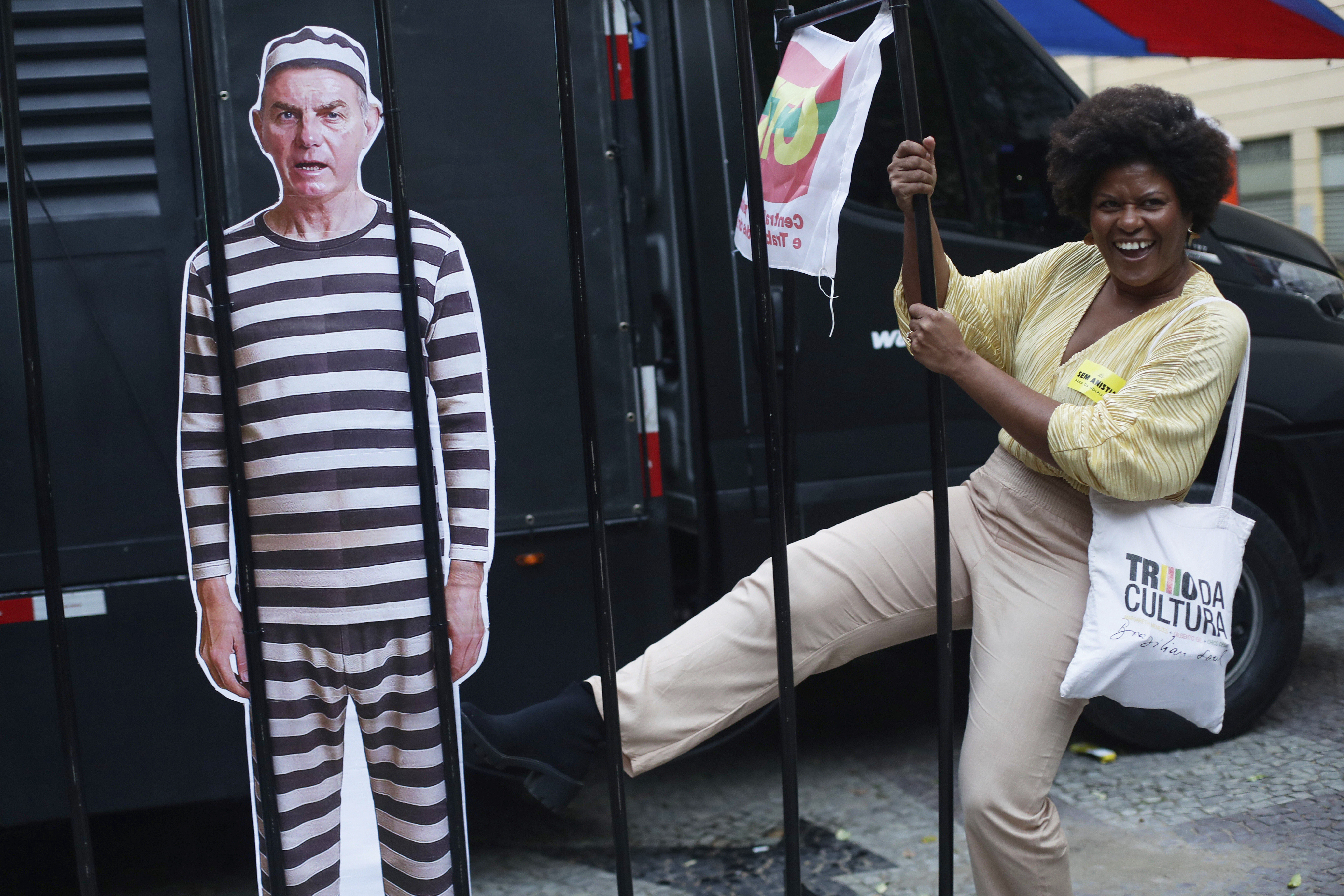 An opponent kicks at a cutout depicting Brazil's former President Jair Bolsonaro in prison garb, as she celebrates a day after the Supreme Court sentenced him to more than 27 years in prison for attempting a coup to remain in office despite his 2022 electoral defeat, in Rio de Janeiro, Friday, Sept. 12, 2025. (Bruna Prado - AP)