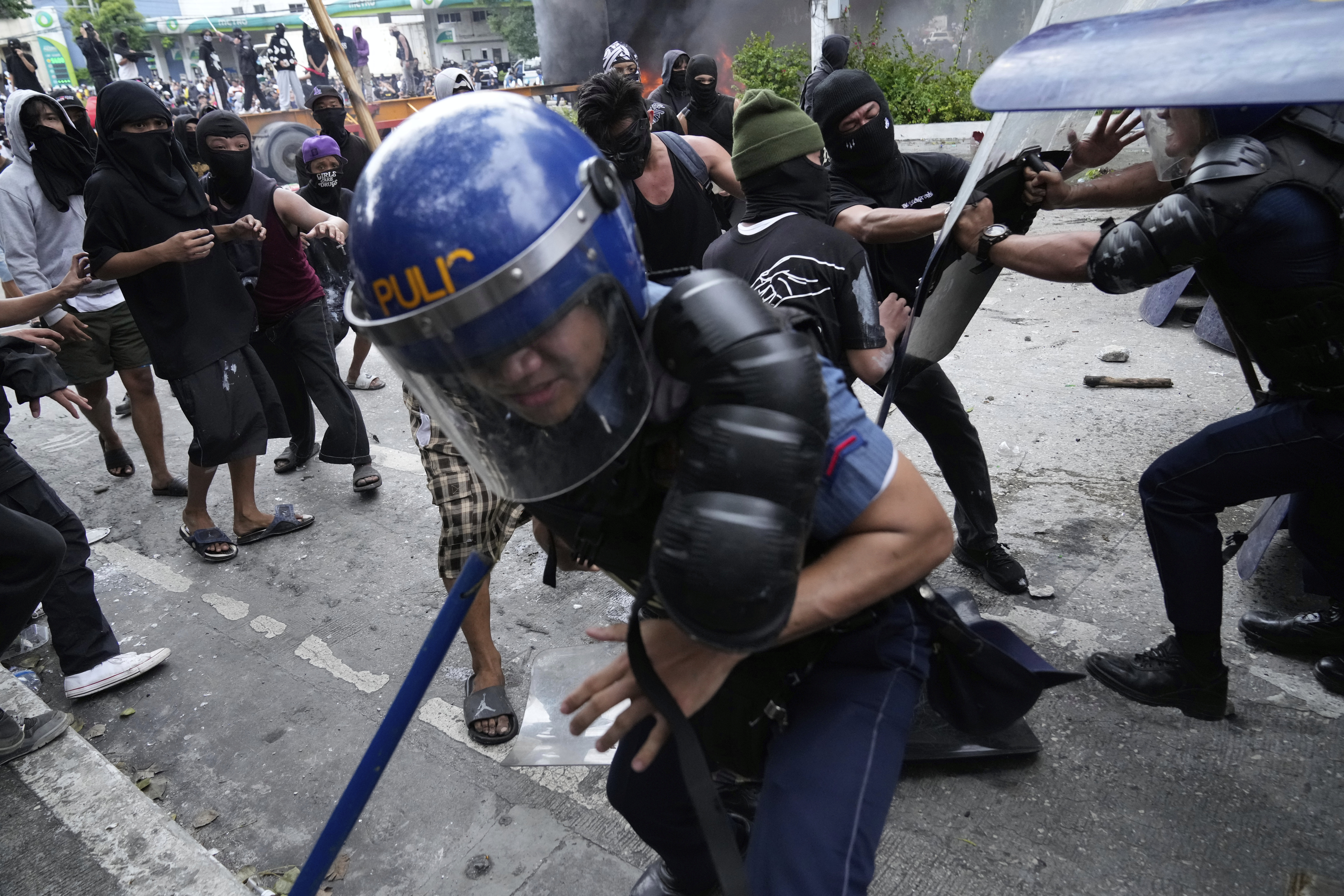 Police escape protesters during a scuffle as they tried to enter the Malacanang presidential palace compound in Manila, Philippines, on Sunday, Sept. 21, 2025. (Aaron Favila - AP)