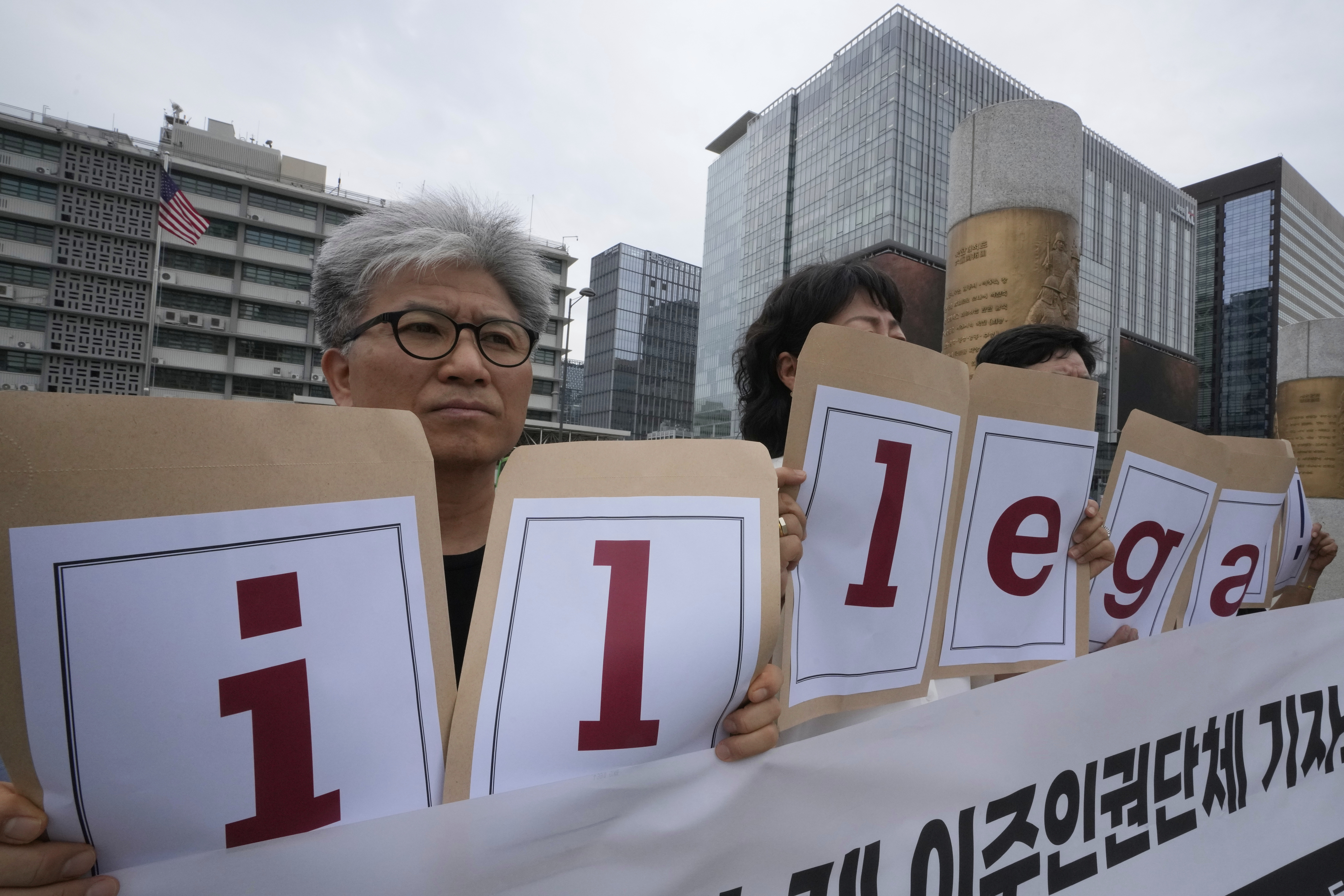 Protesters hold a sign that reads, 