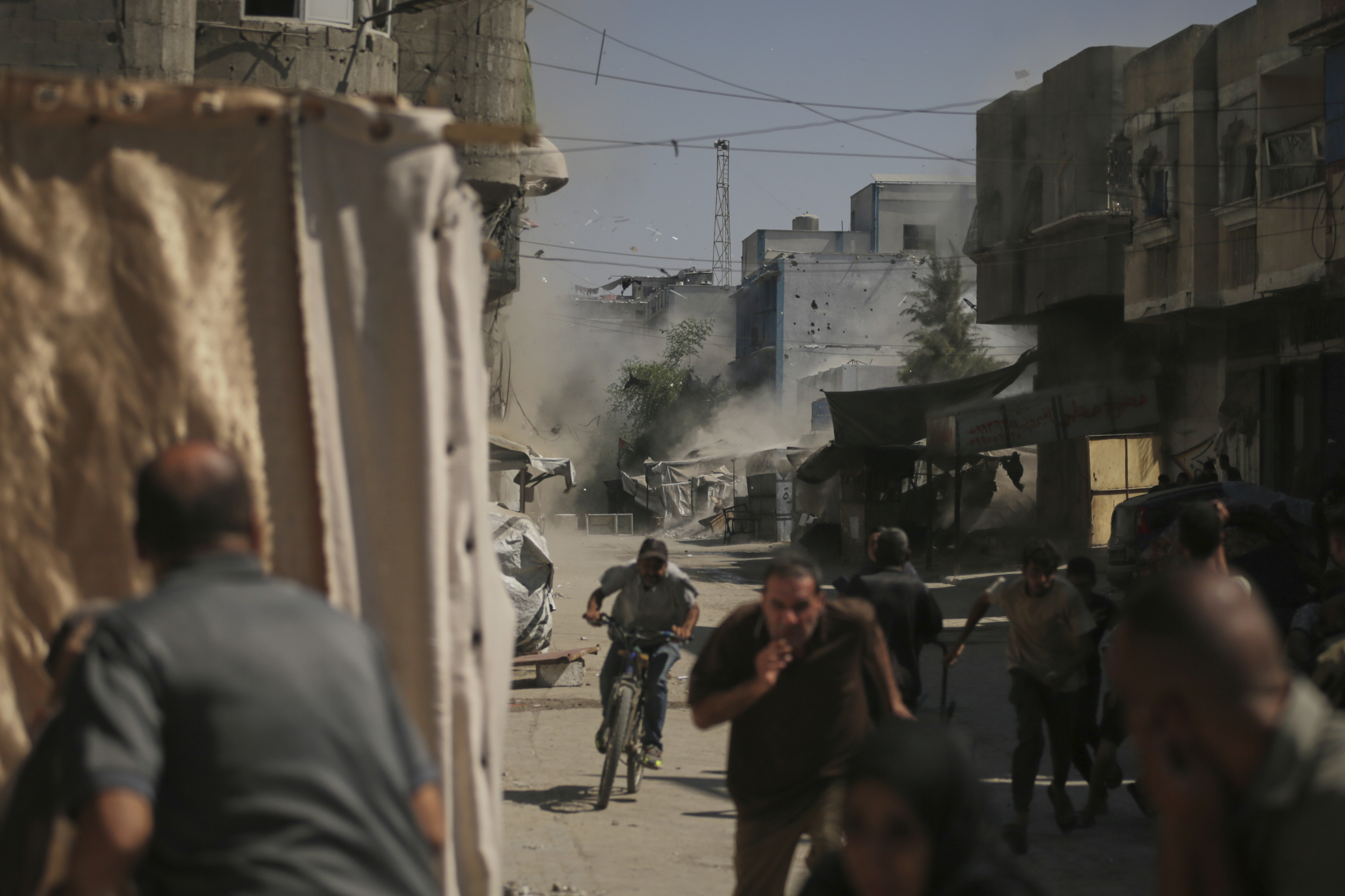 Palestinians run for cover during an Israeli military strike on a building in Gaza City, Saturday, Sept. 13, 2025. (Yousef Al Zanoun - AP)