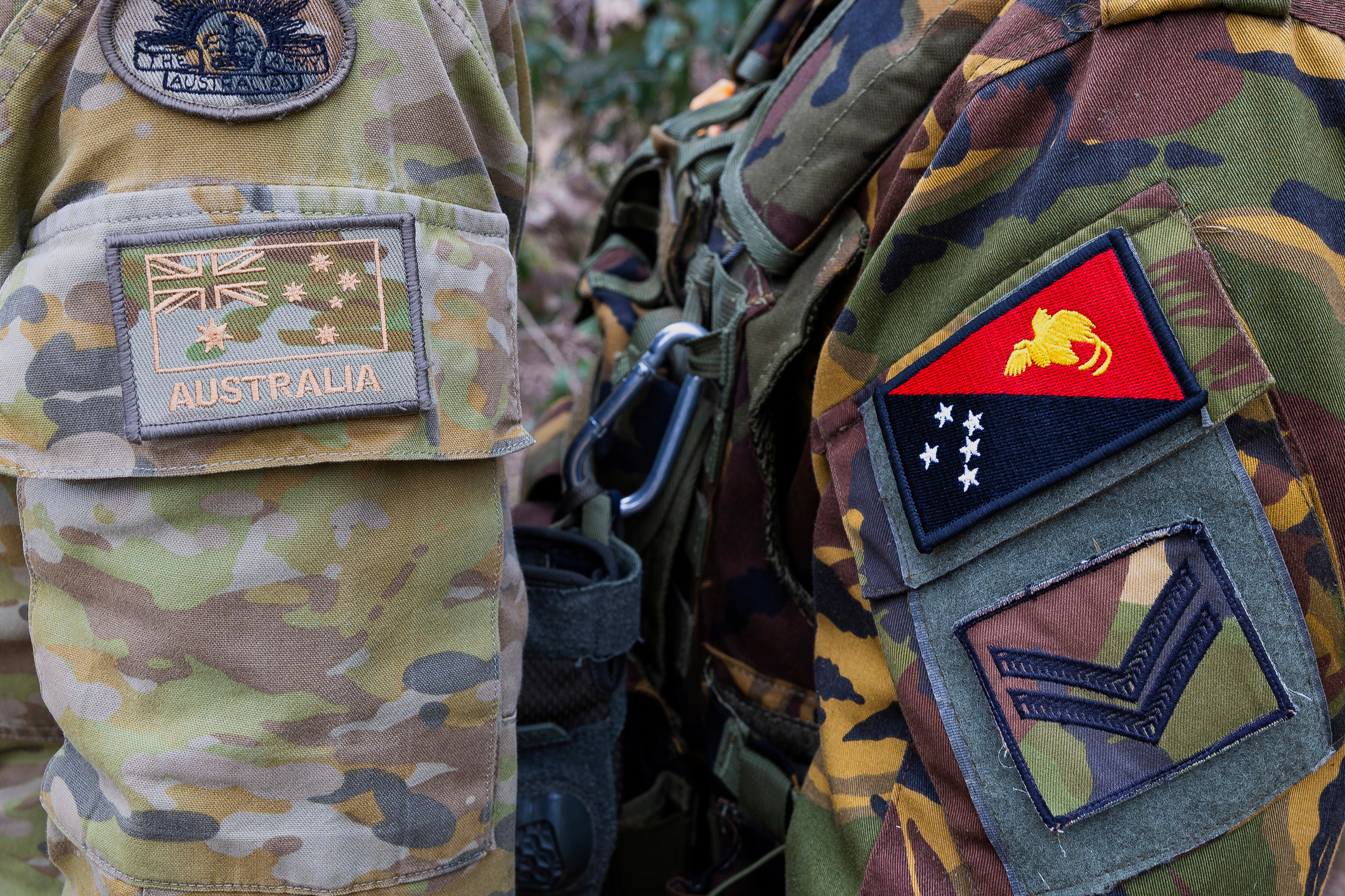 This photo shows the emblem of an Australian Army soldier, left, and a Papua New Guinea Defence Force soldier during an exercise at Talisman Sabre in Townsville, Australia, on July 21, 2025. (LCPL Jessica Gray - Australian Army)