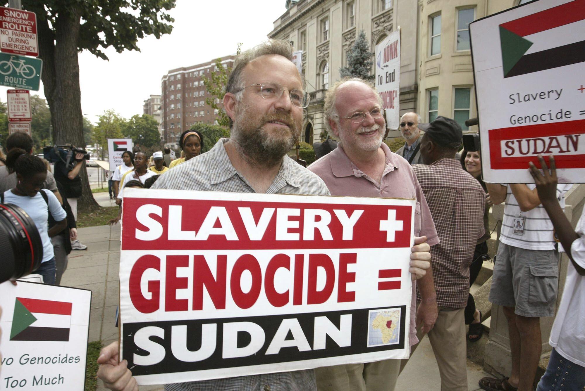 FILE - Founders of Ben & Jerry's Ice Cream Jerry Greenfield , left, and Ben Cohen, pink shirt, protest in front of Sudan's embassy July 29, 2004, in Washington. (CHARLES DHARAPAK - AP)