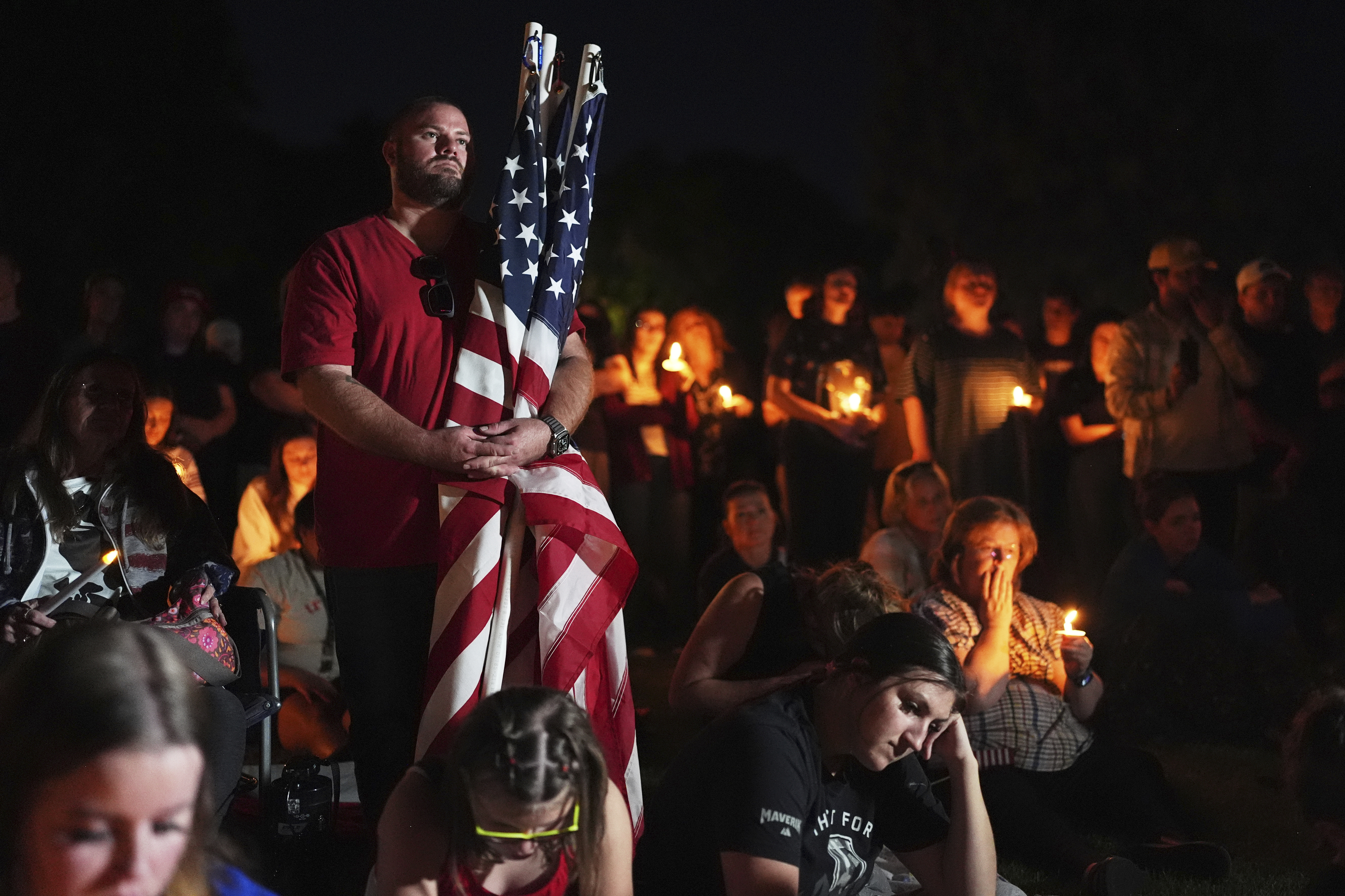 Ryan Shaw holds American flags during a vigil for Charlie Kirk on Friday, Sept. 12, 2025, in Provo, Utah. (Lindsey Wasson - AP)