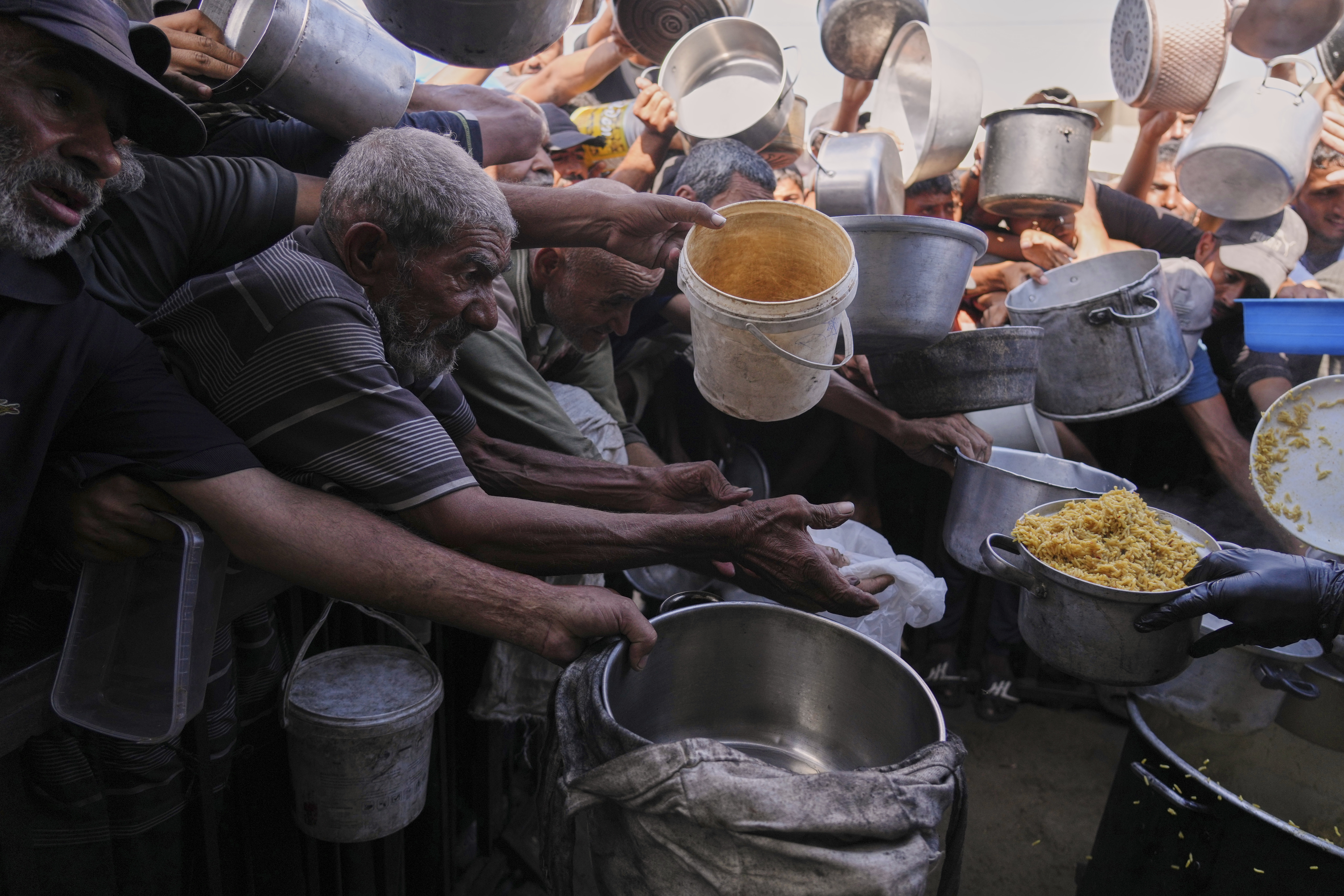 Palestinians struggle to get donated food at a community kitchen in Khan Younis, southern Gaza Strip, Friday, Sept. 19, 2025. (Jehad Alshrafi - AP)