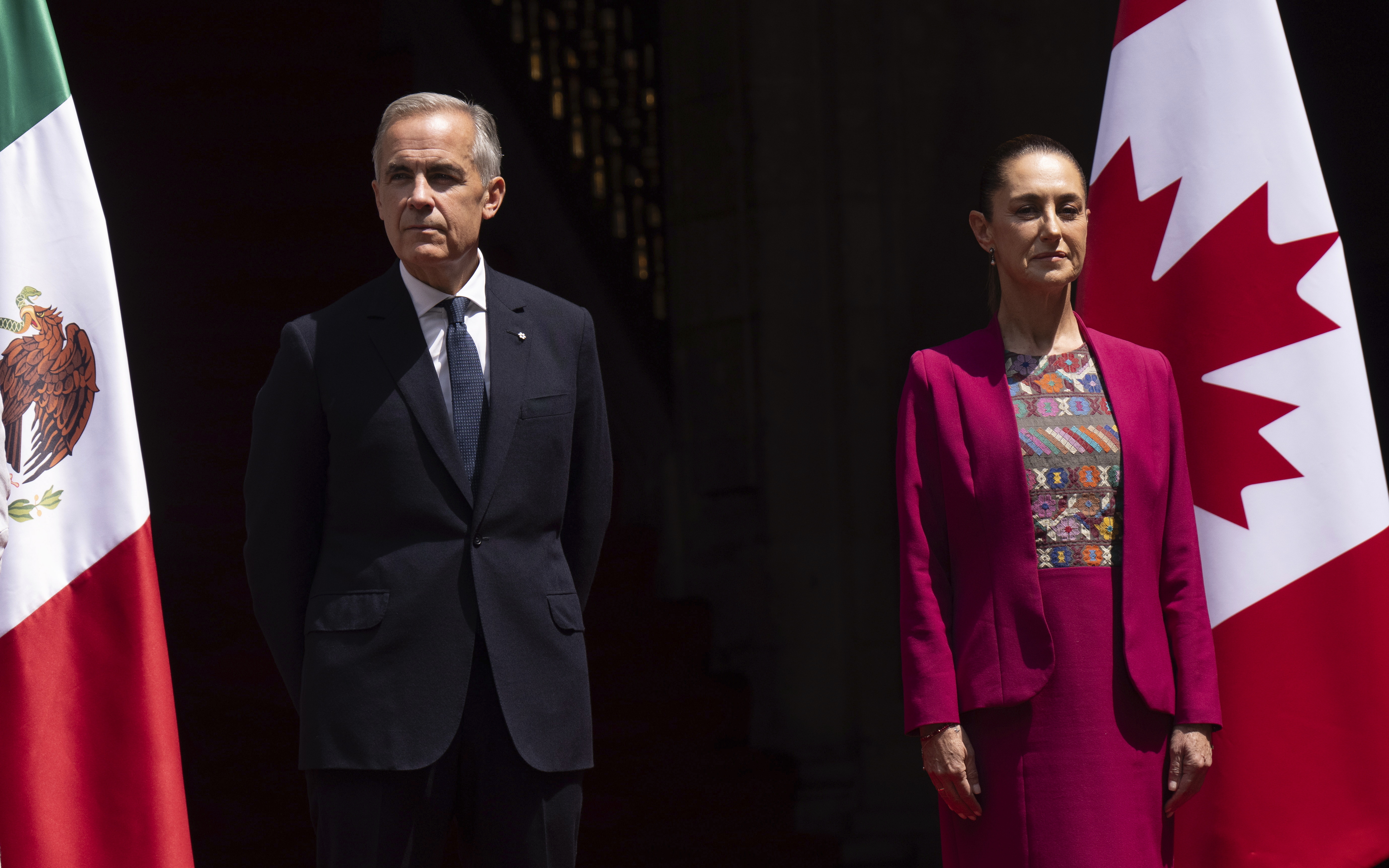Canada's Prime Minister Mark Carney and Mexican President Claudia Sheinbaum stand on the podium during an official welcome ceremony at the National Palace in Mexico City, Thursday, Sept. 18, 2025. (Adrian Wyld - The Canadian Press)