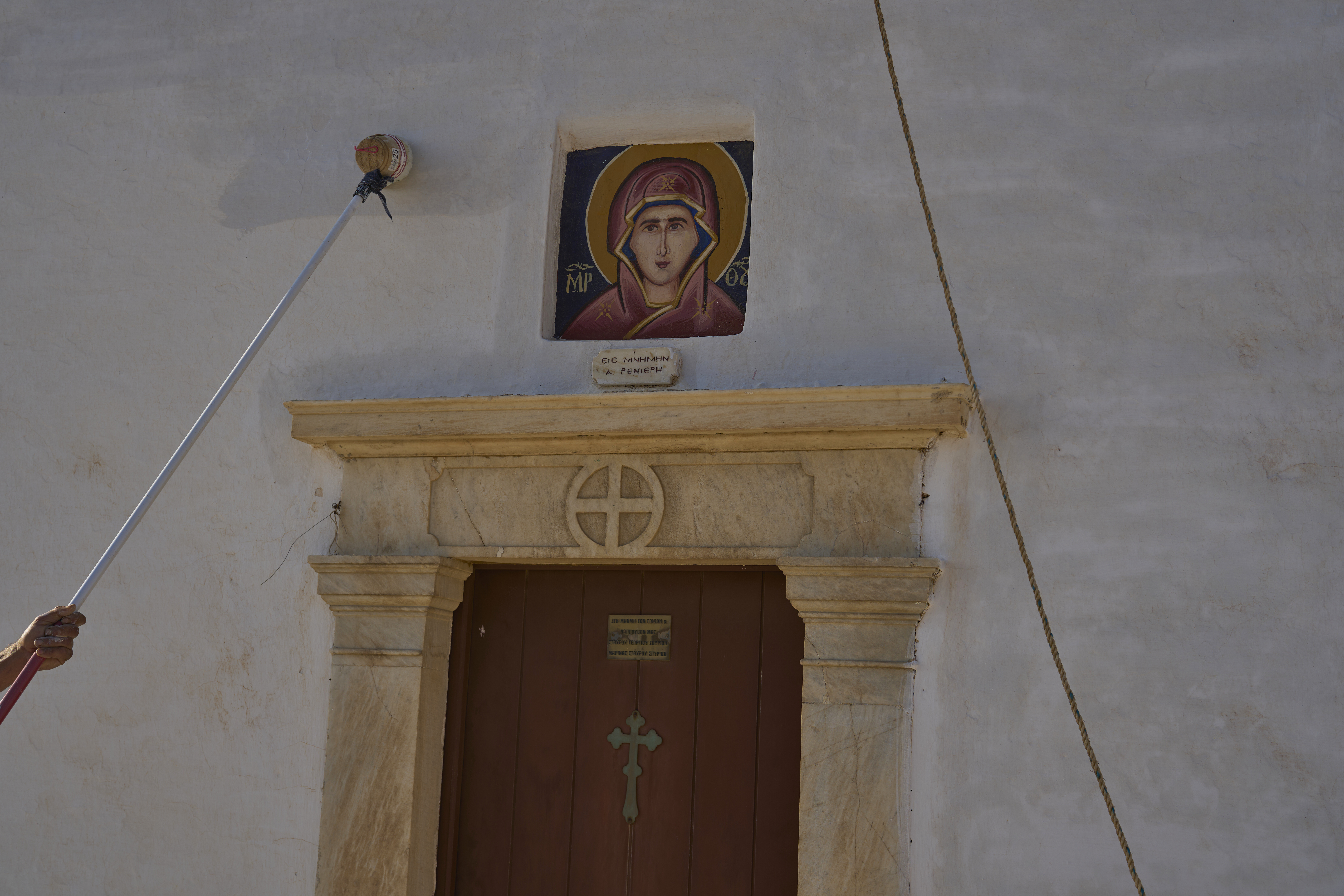 Naim Domi, 50, an Albanian worker who has lived in Greece for 17 years, paints the Panagia Faneromeni co-family-owned chapel, near the village of Pyrgos, on the island of Tinos, Greece, Sunday, Sept. 7, 2025. (Petros Giannakouris - AP)