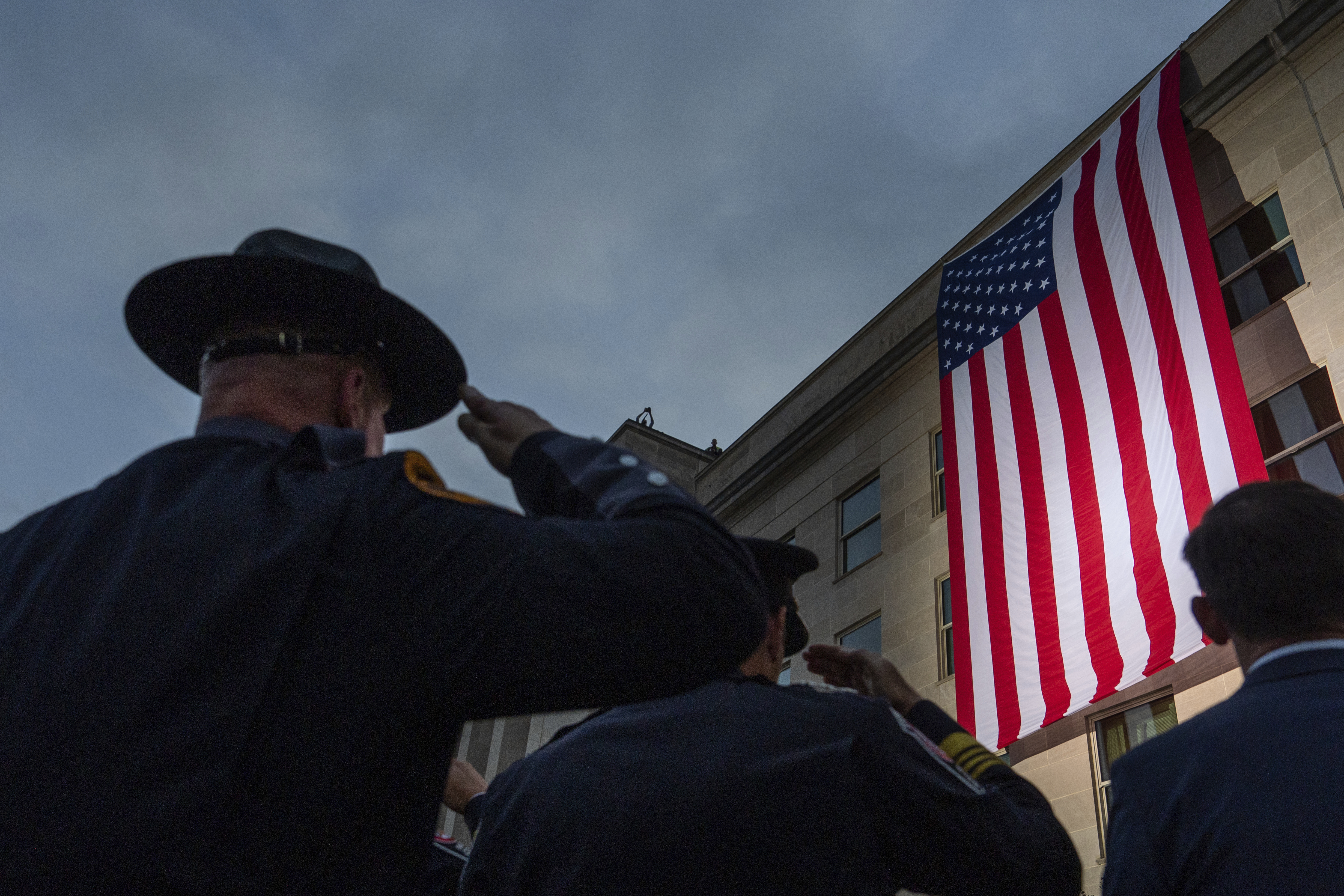 First responders salute as an American flag is unfurled from the top of the Pentagon at sunrise, Thursday, Sept. 11, 2025, in Washington. (Julia Demaree Nikhinson - AP)