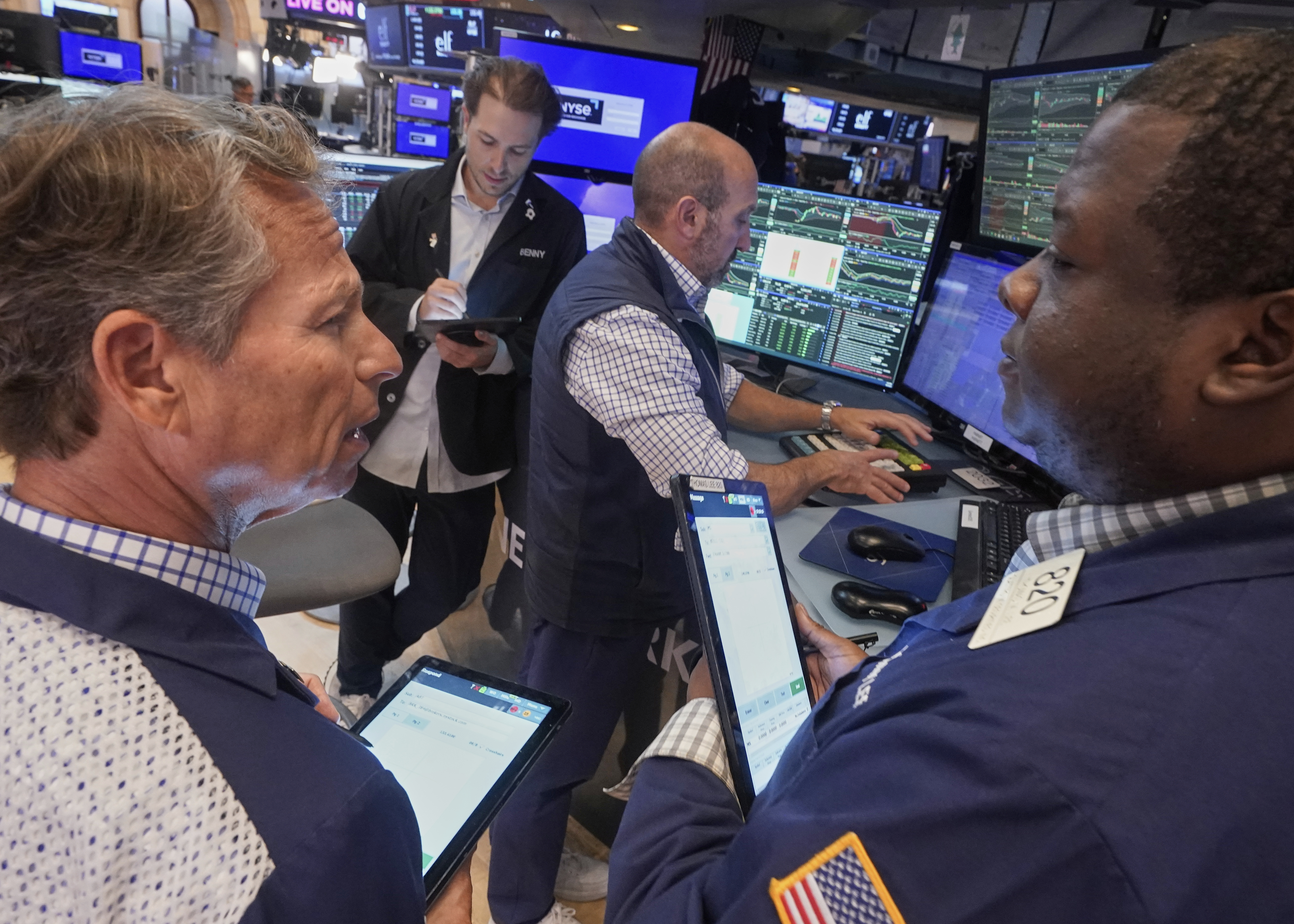 Traders Robert Charmak, left, Thomas Lee, right, and Ben Tuchman, background left, work with specialist James Denaro on the floor of the New York Stock Exchange, Friday, Sept. 5, 2025. (Richard Drew - AP)