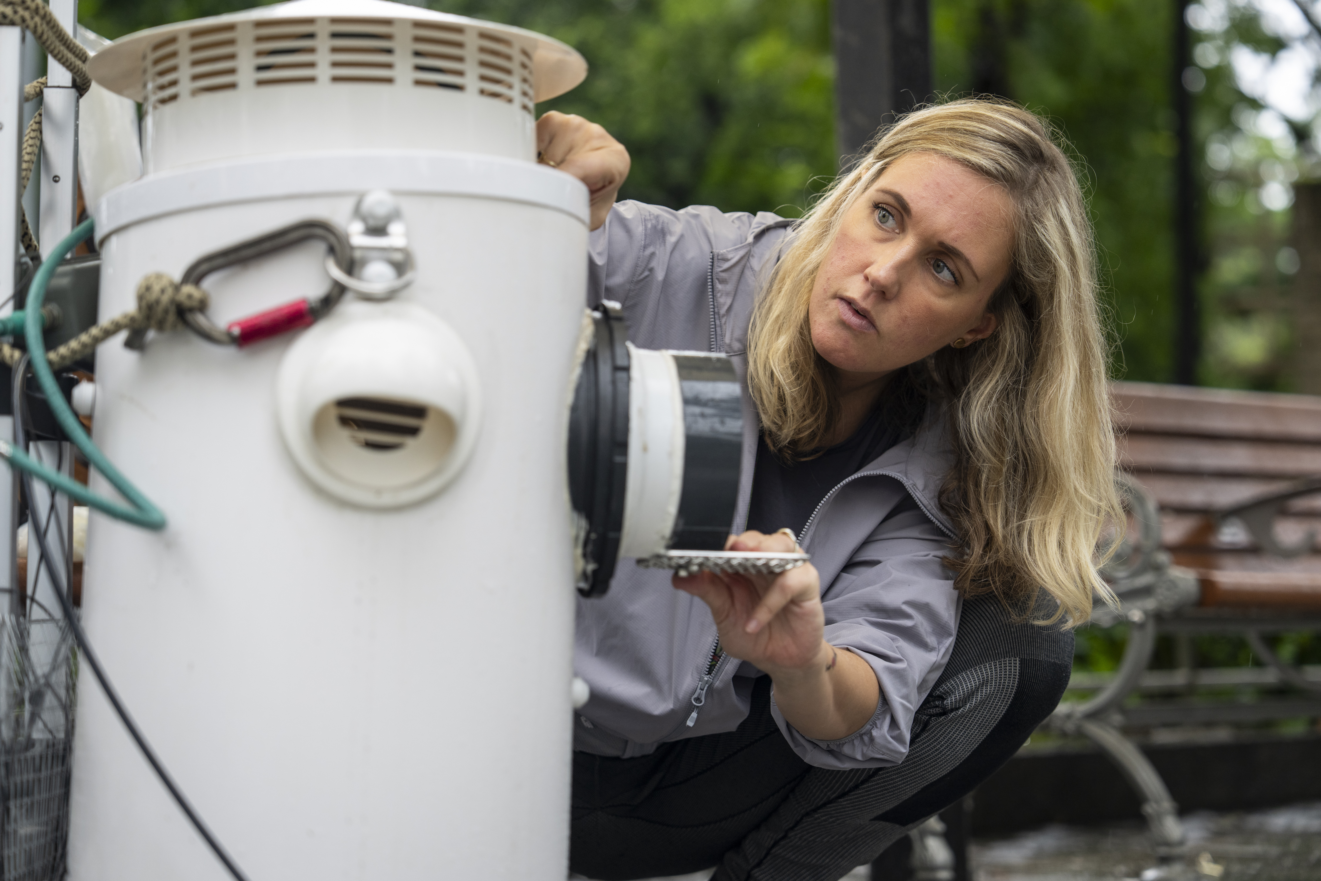 Astrid Andersson, a postdoctoral researcher at the University of Hong Kong, adjusts an artificial nest box for wild yellow-crested cockatoos in Victoria Park in Hong Kong, on Aug. 18, 2025. (Chan Long Hei - AP)