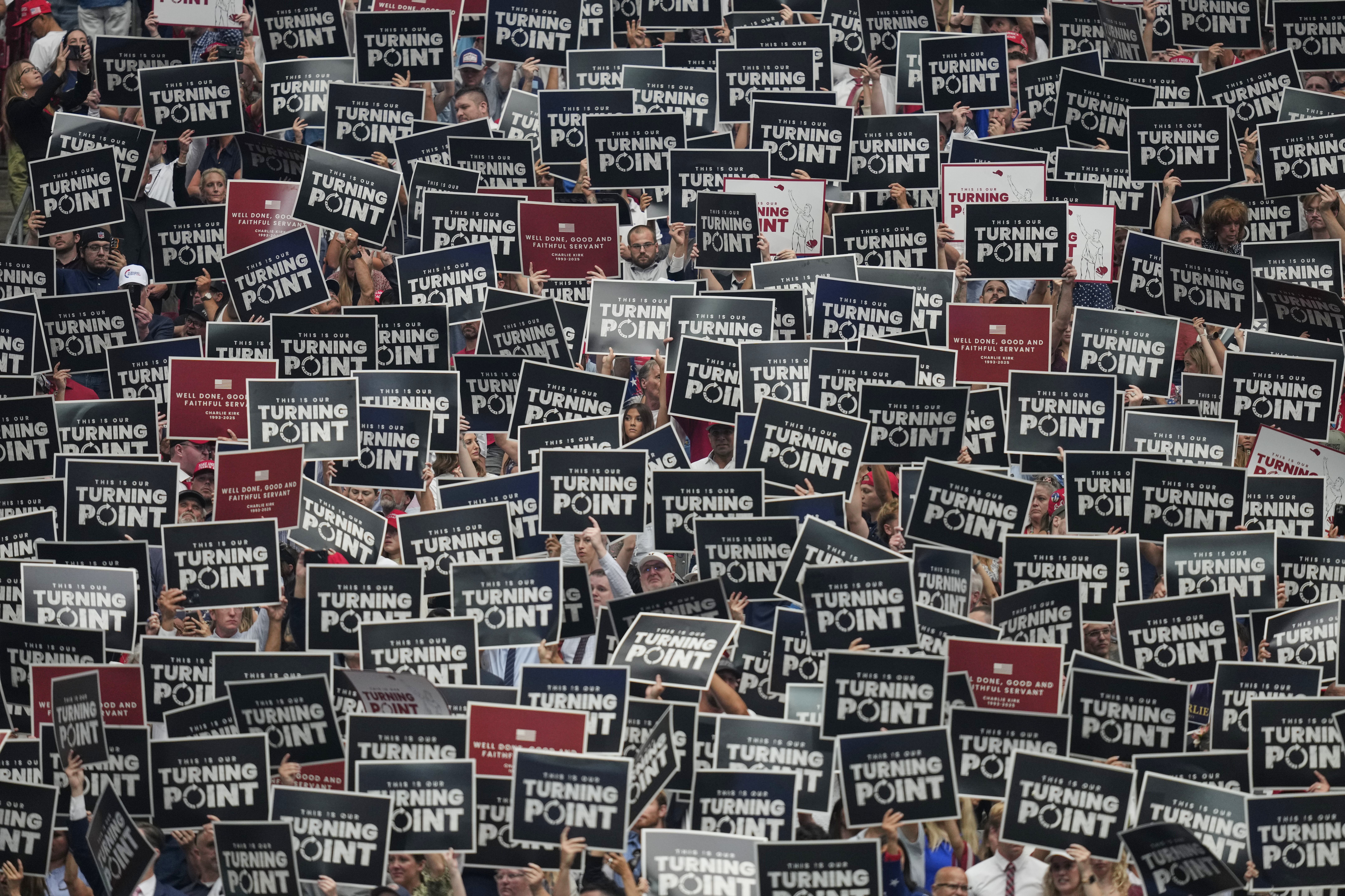 People hold up signs during a memorial for conservative activist Charlie Kirk, Sunday, Sept. 21, 2025, at State Farm Stadium in Glendale, Ariz. (John Locher - AP)