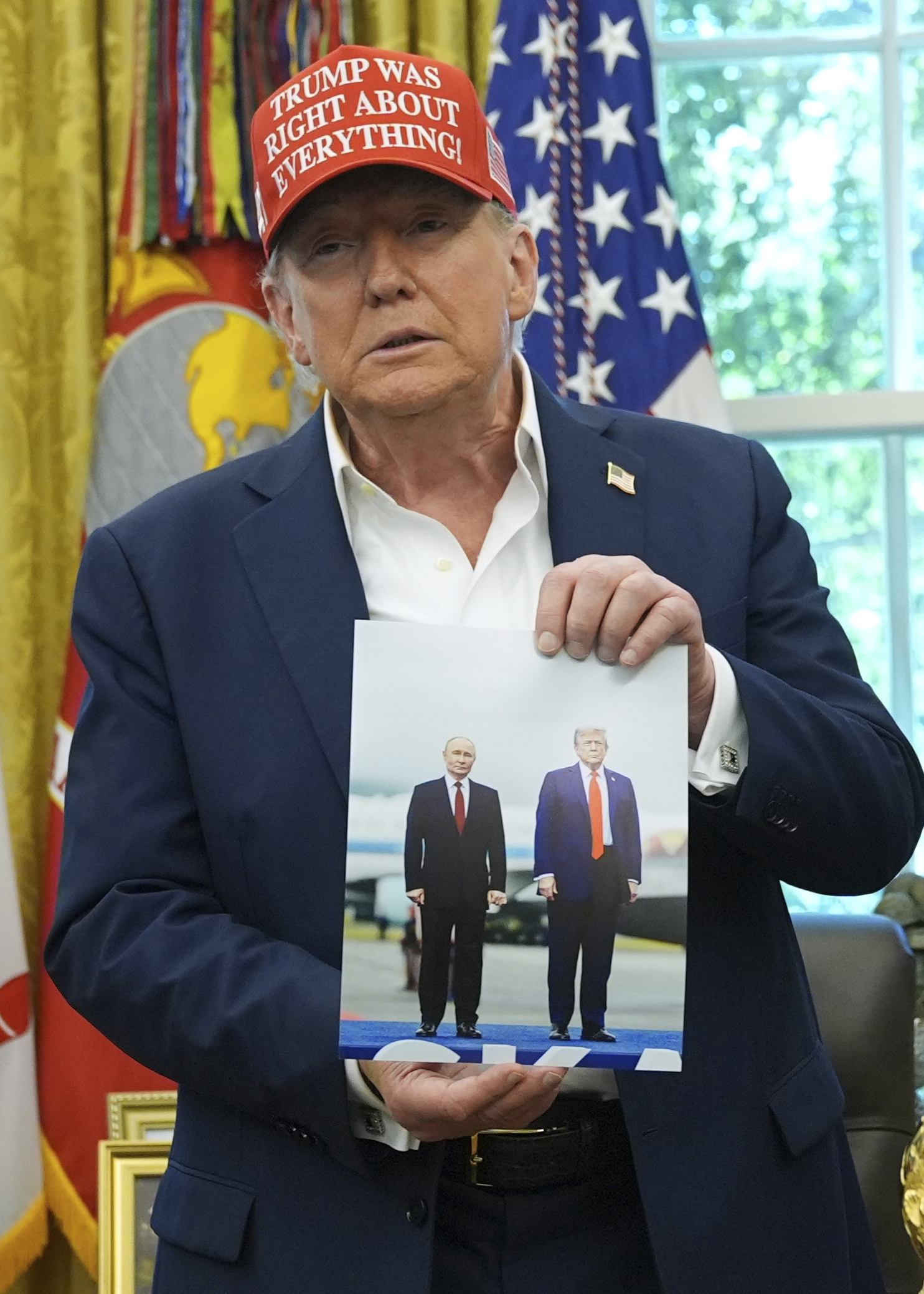 President Donald Trump holds a photo of himself with Russian President Vladimir Putin during an announcement in the Oval Office of the White House, Friday, Aug. 22, 2025, in Washington. (Jacquelyn Martin - AP)