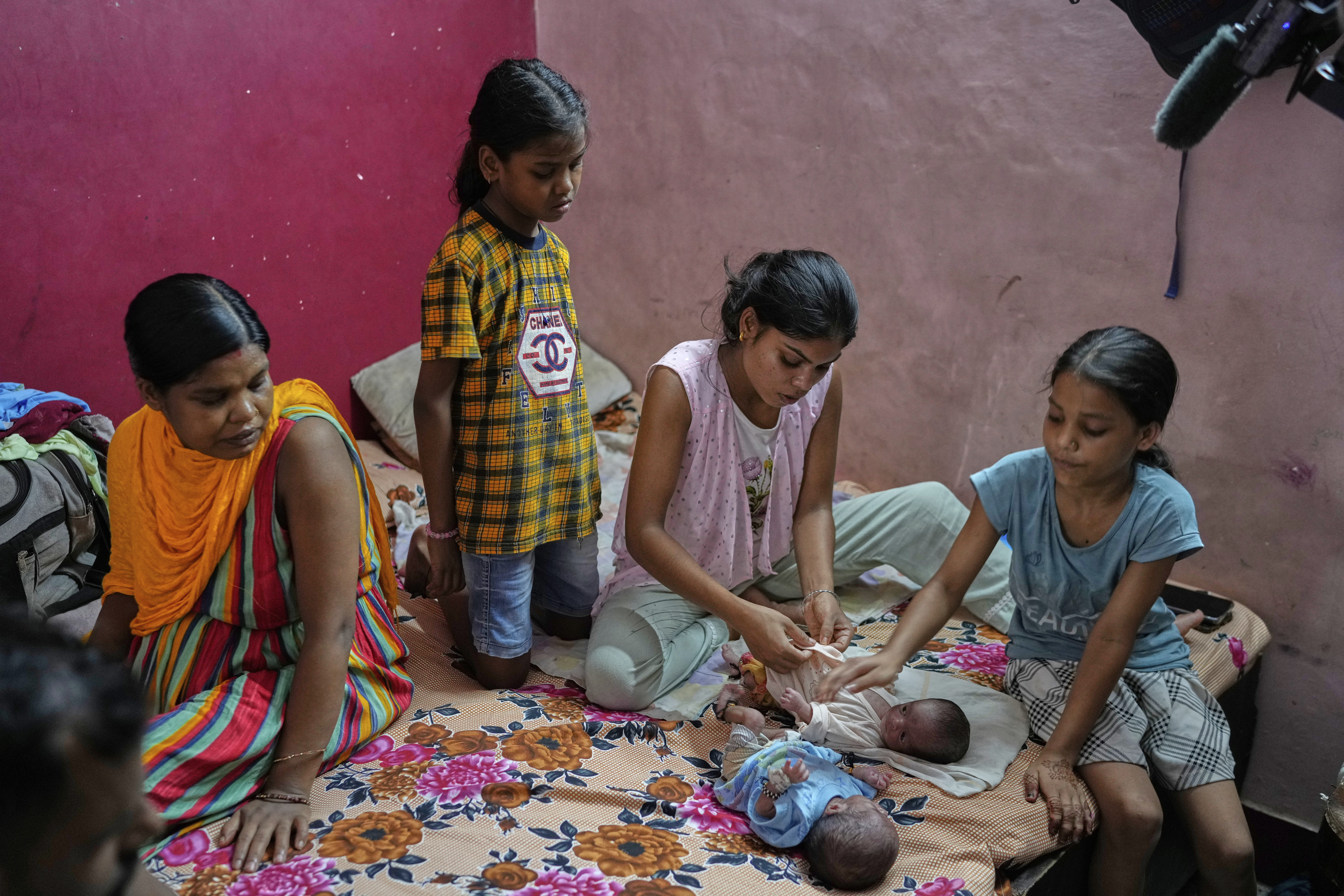 Antima Kumari, center, trained in Care Companion Program (CCP), takes care of her nephews as her sister Lilawati watches in their house in Gurugram, a satellite city of New Delhi, India, on Aug. 8, 2025. (Manish Swarup - AP)