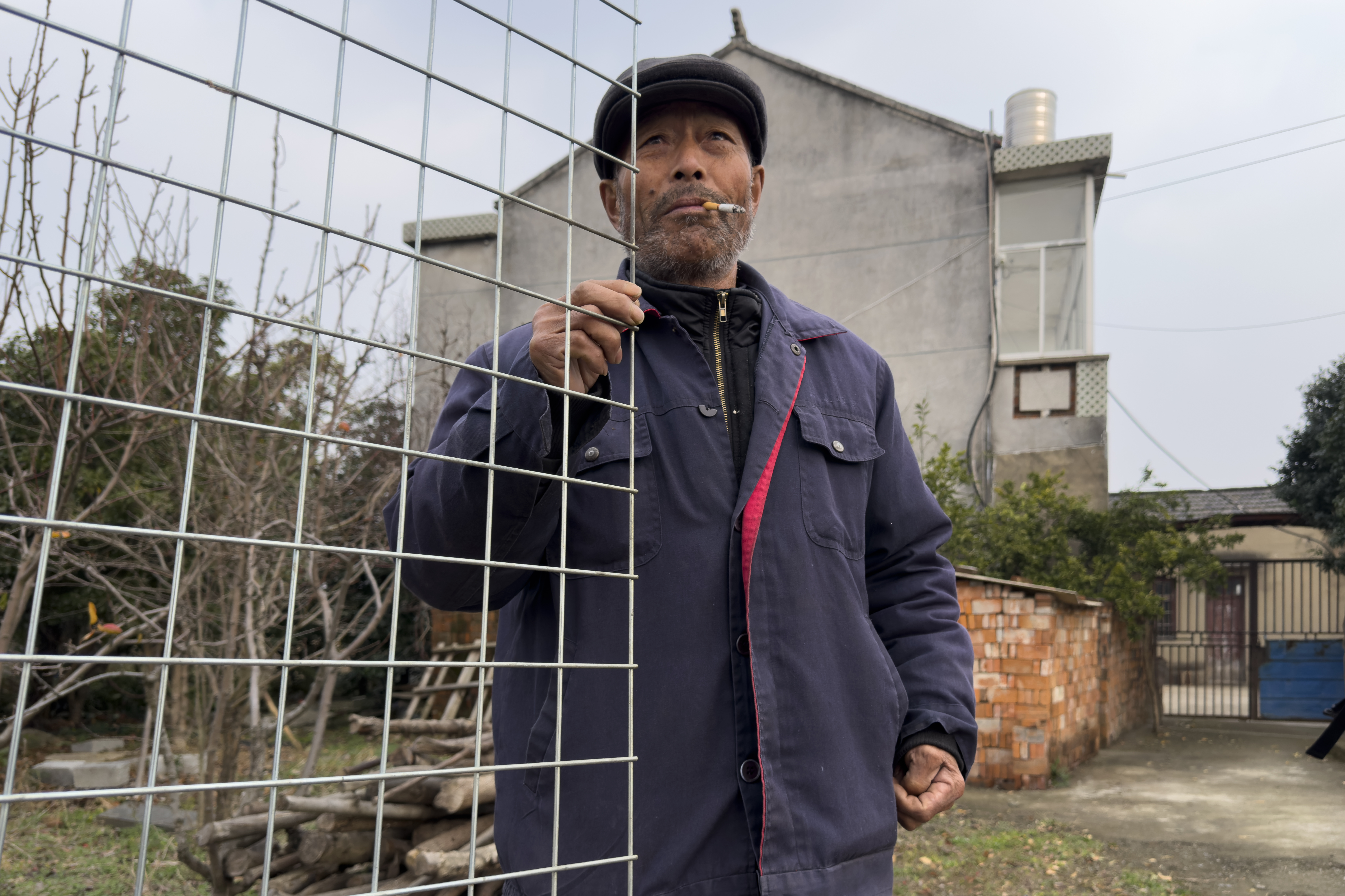 Petitioner Yang Guoliang stands at his gate outside his home in Changzhou in eastern China's Jiangsu Province, Friday, Dec. 13, 2024. (Ng Han Guan - AP)